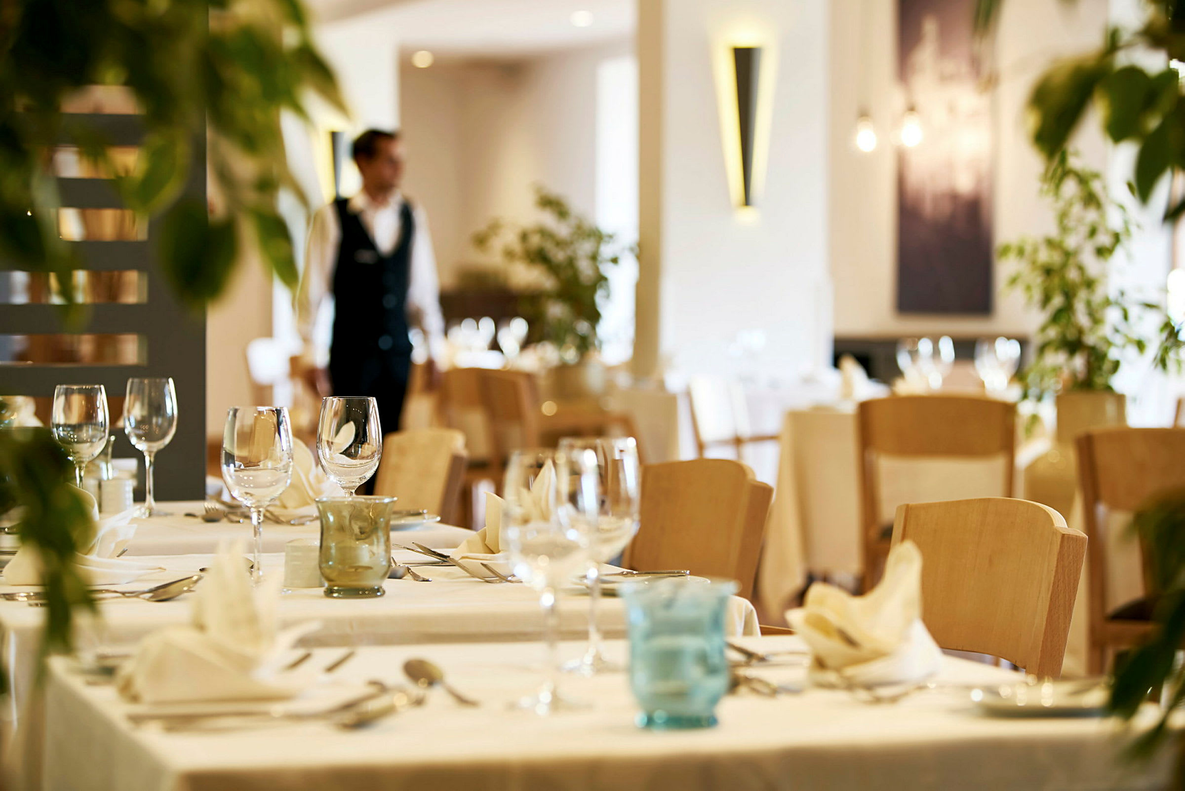 En restaurant med dækkede borde og glas. (AI-genereret tekst)