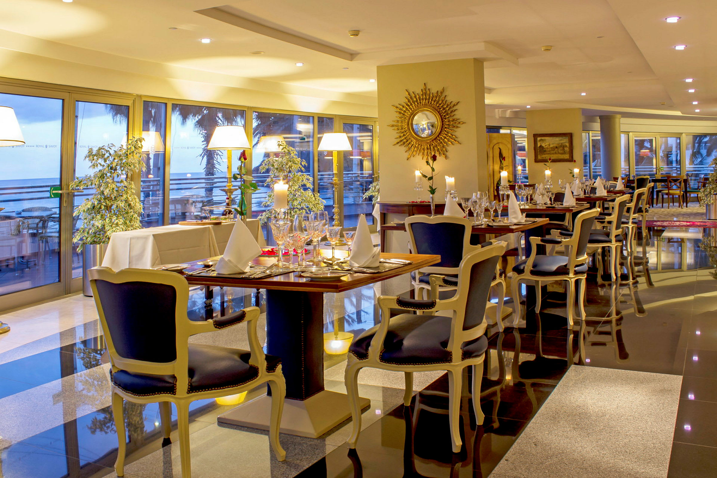 En elegant indrettet restaurant med dækkede borde og store glasvinduer med udsigt. (AI-genereret tekst)