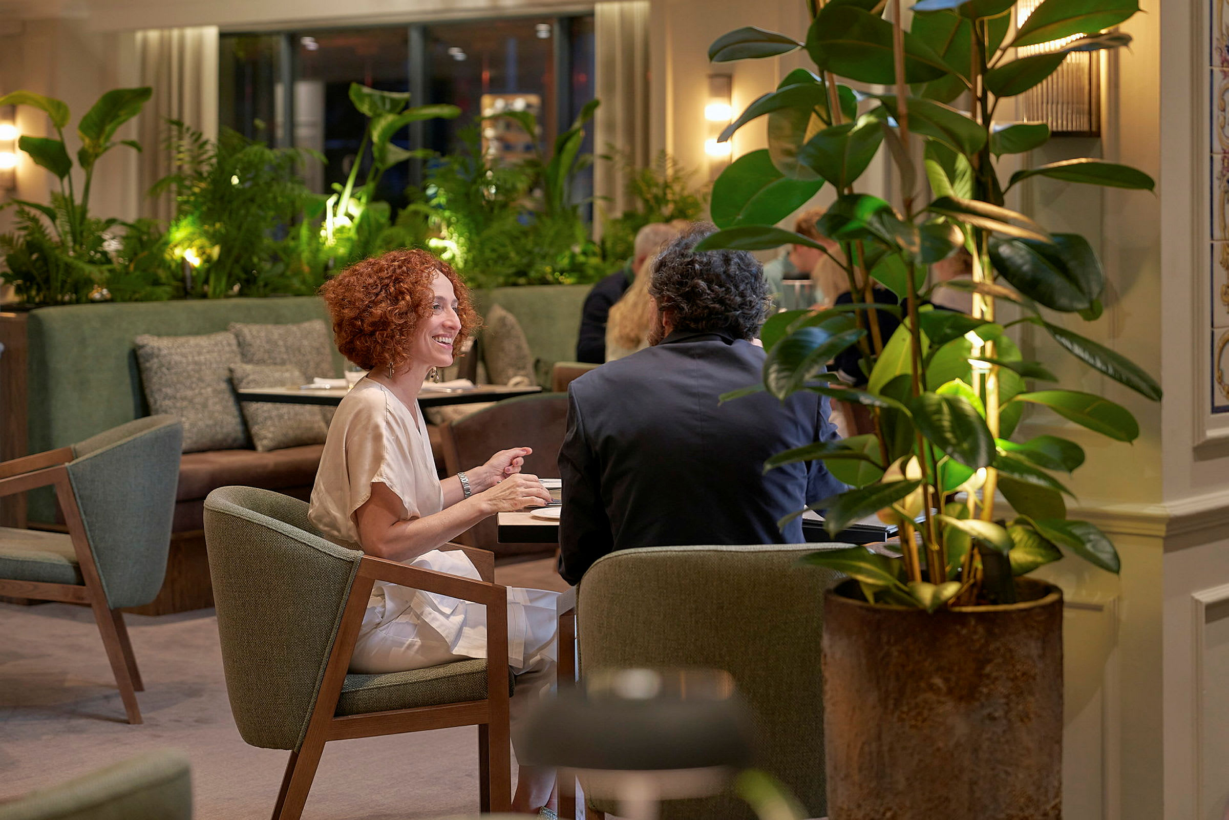 To personer sidder ved et bord i en hyggelig restaurant. (AI-genereret tekst)