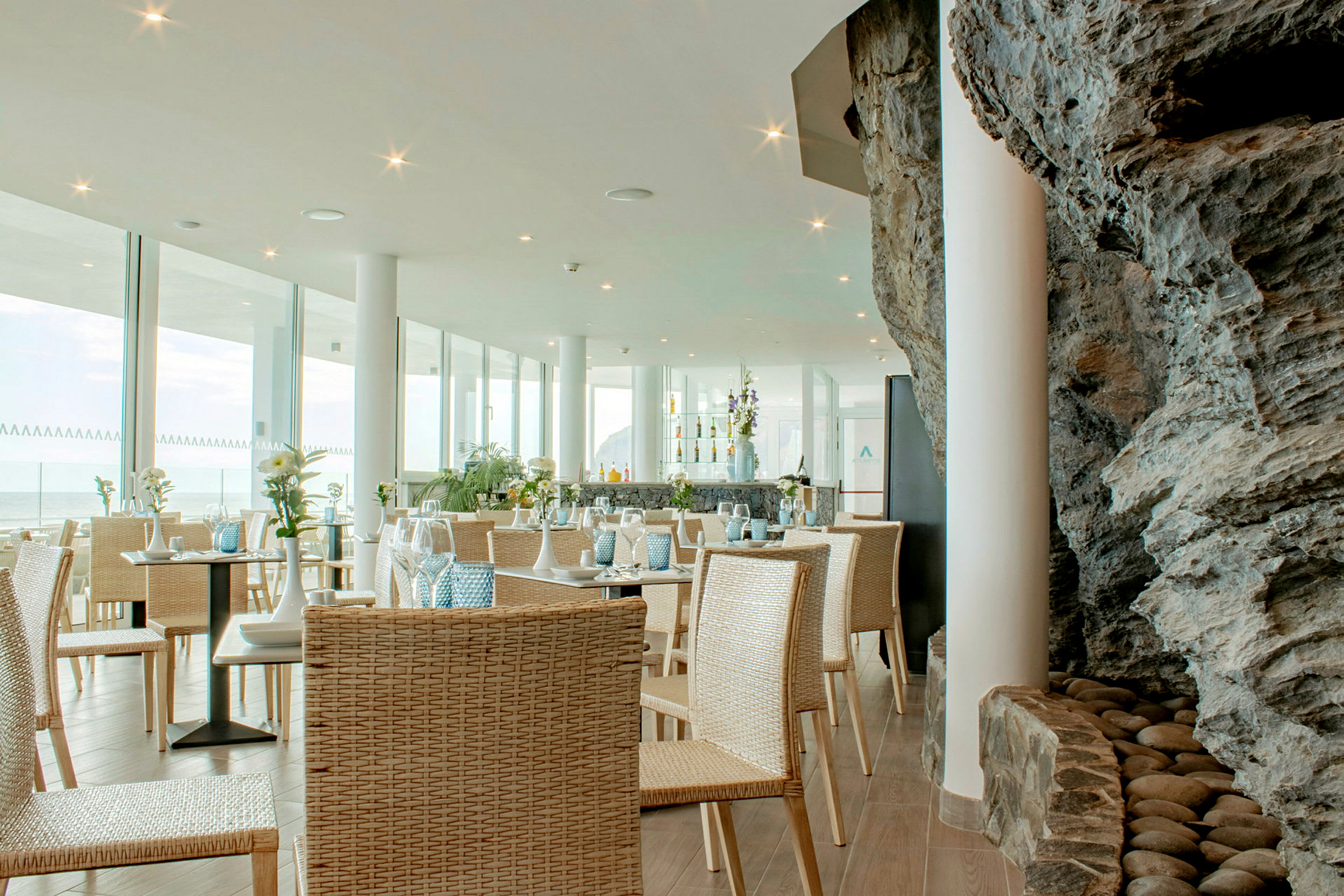En restaurant med glasvægge og indretning i naturmaterialer. (AI-genereret tekst)