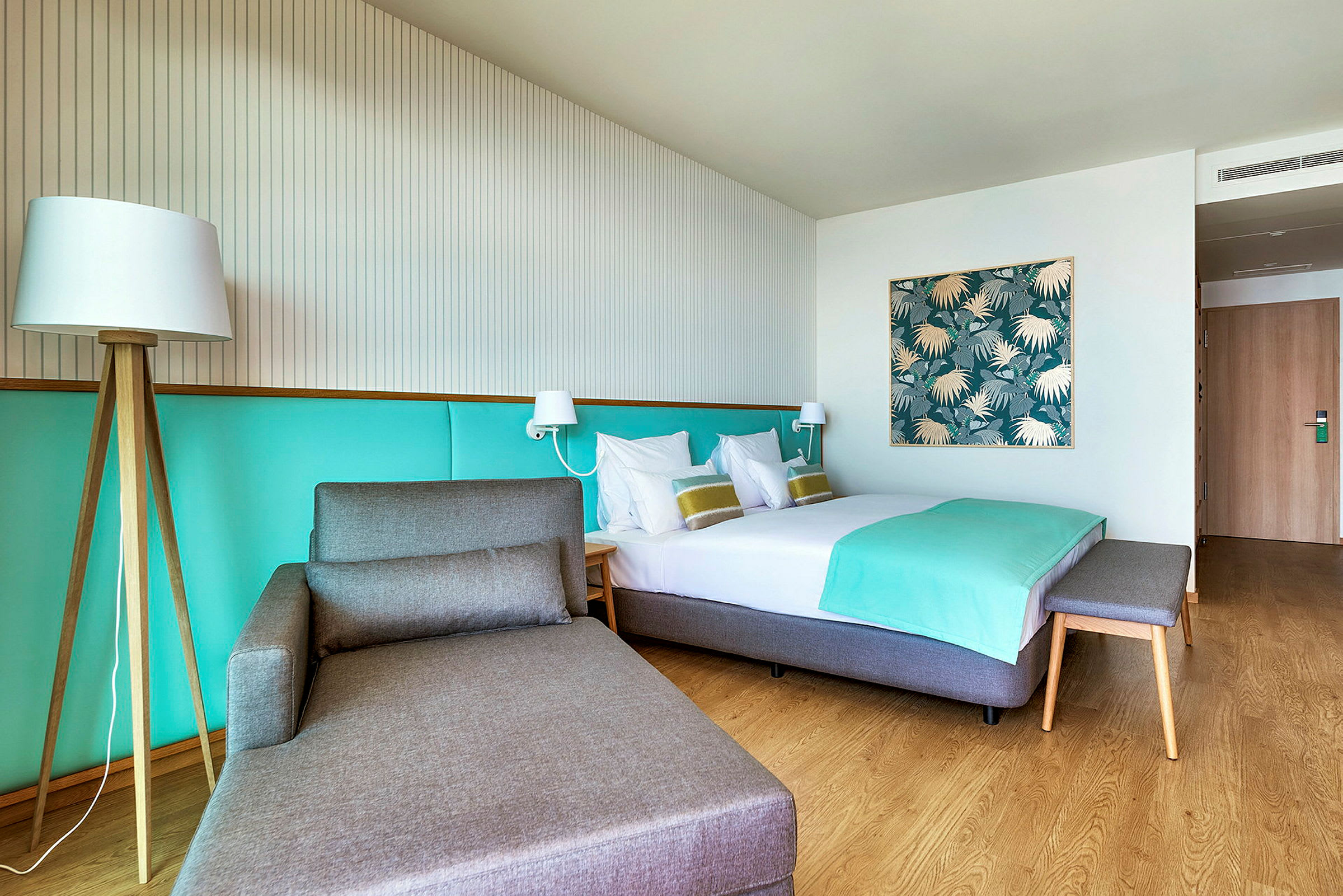 Hotelværelse med en seng, en siddemøbel og lys dekoration. (AI-genereret tekst)