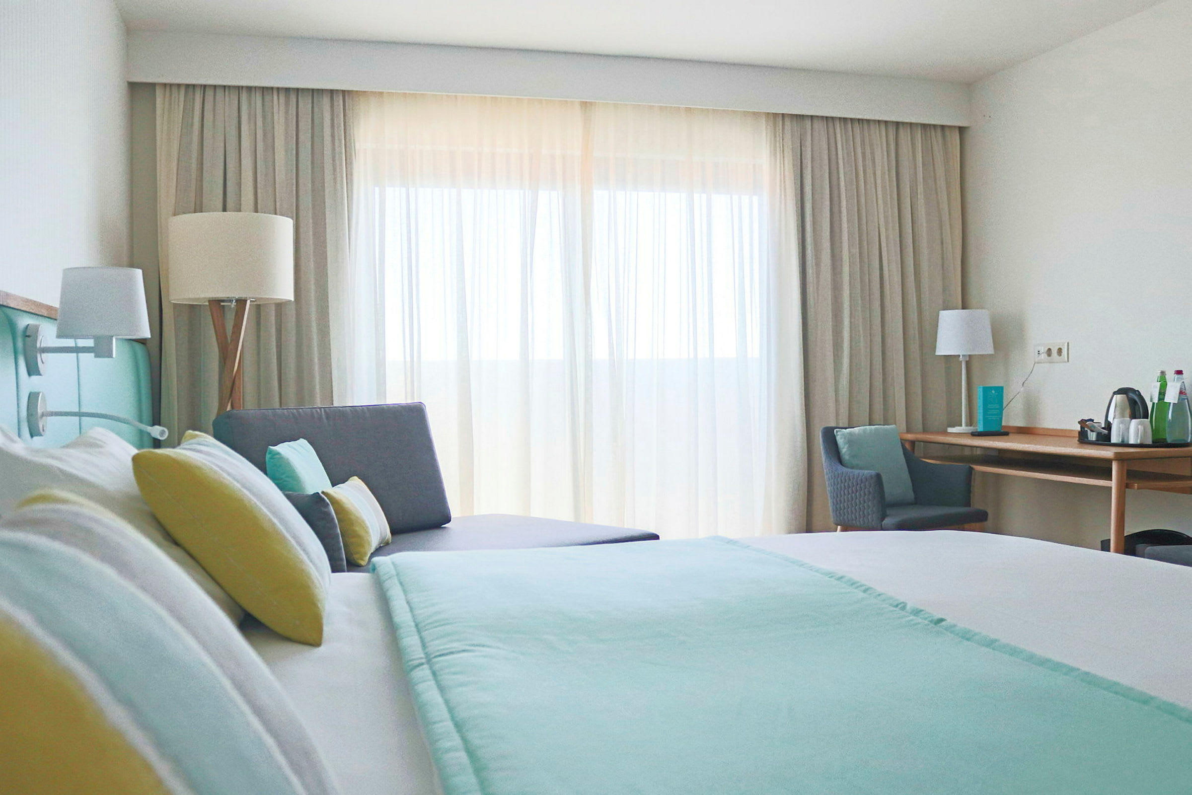 Moderne hotelværelse med en dobbeltseng, sofa og skrivebord. (AI-genereret tekst)