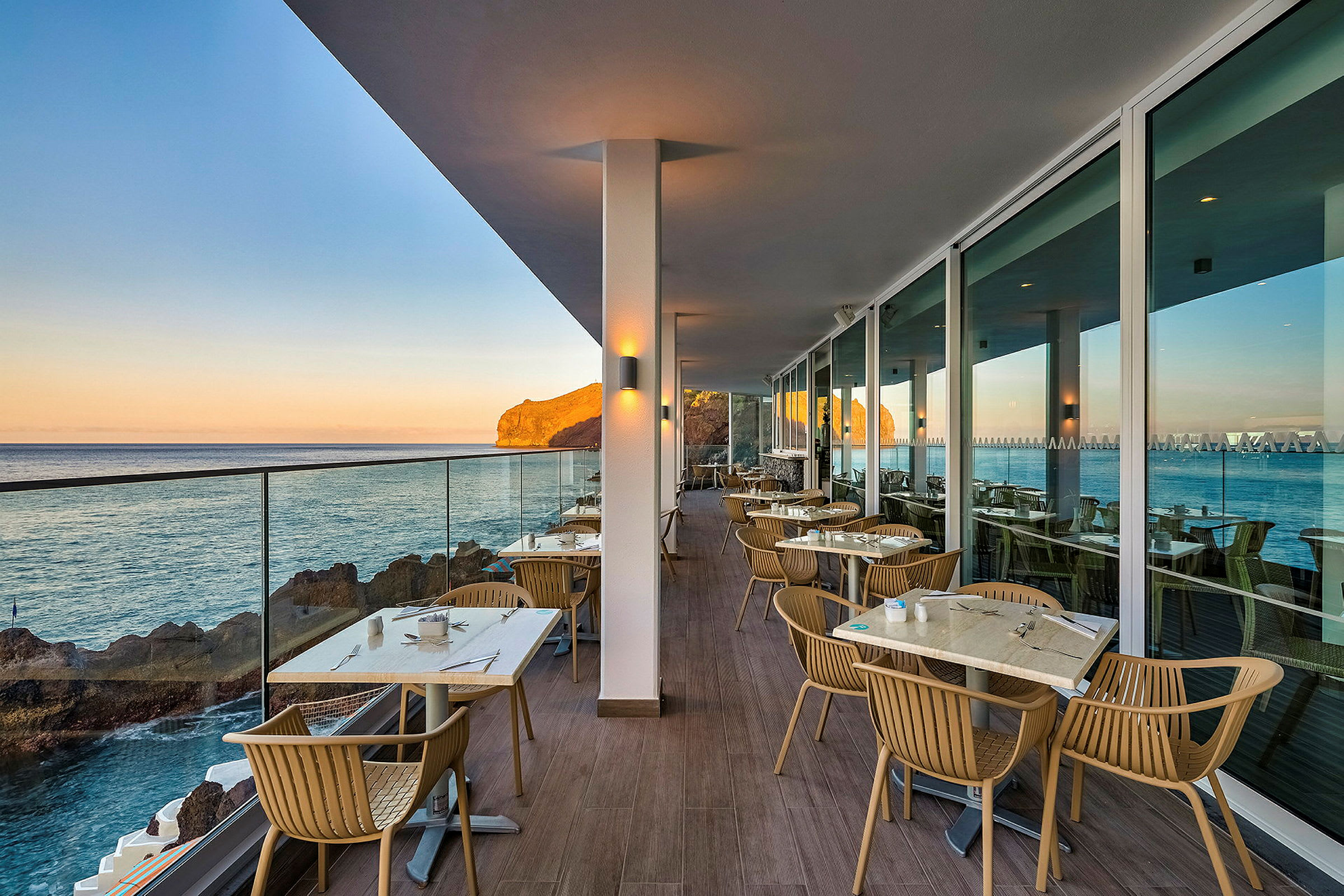 Udendørs servering med havudsigt og borde på en terrasse. (AI-genereret tekst)