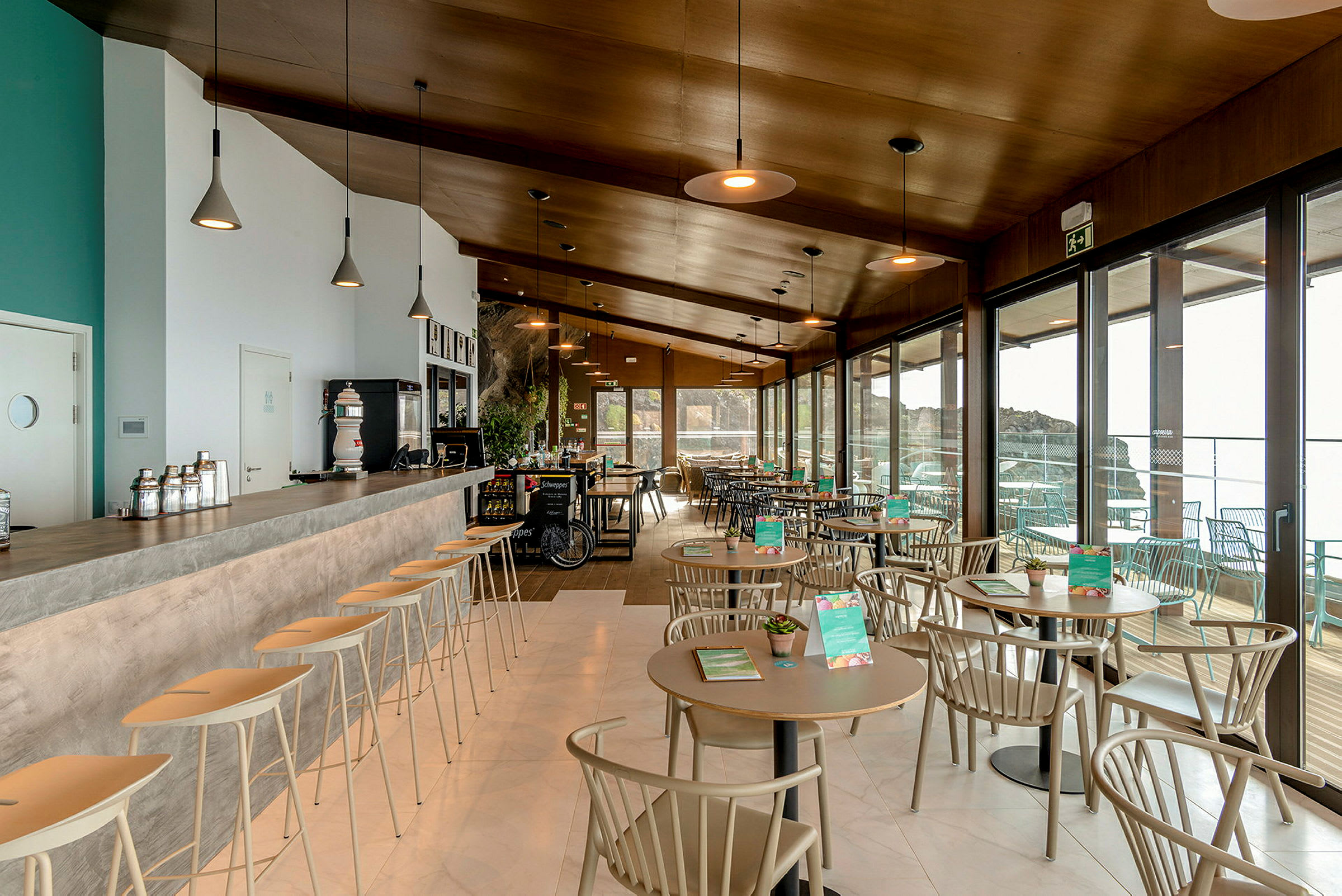 Moderne caféindretning og bar med store vinduer i baggrunden. (AI-genereret tekst)