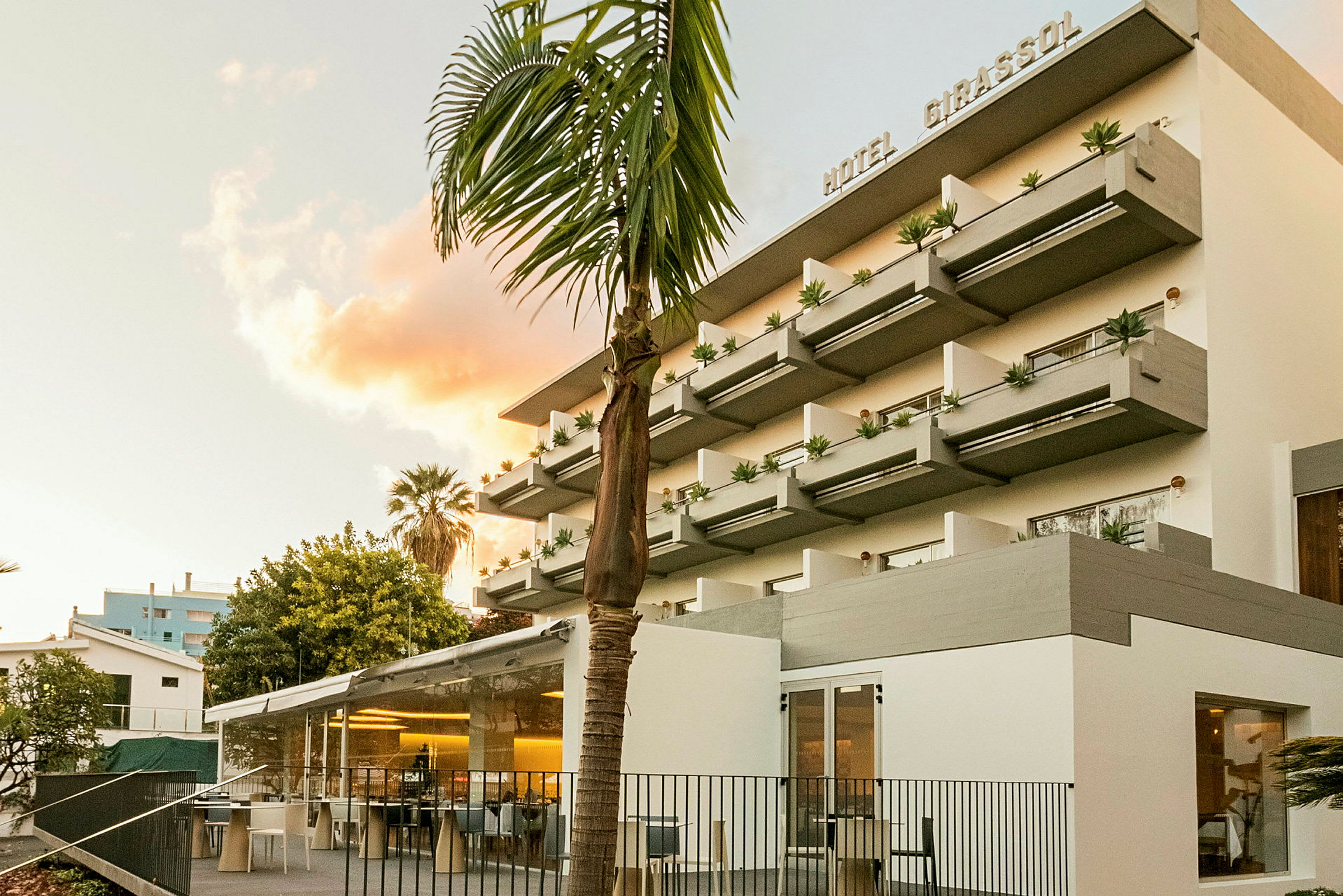 Hotellets facade med moderne altaner og træer i forgrunden. (AI-genereret tekst)