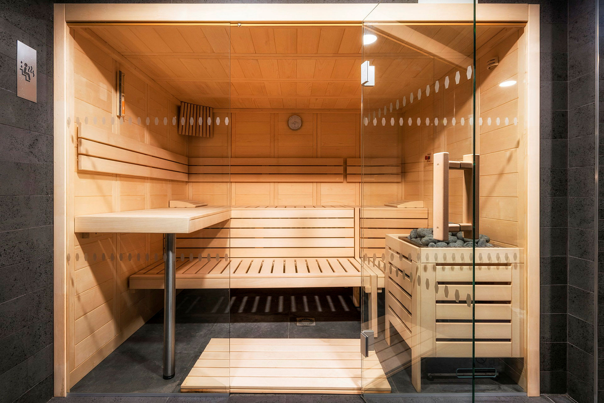 Billede af en moderne sauna med træinteriør og glasdør. (AI-genereret tekst)