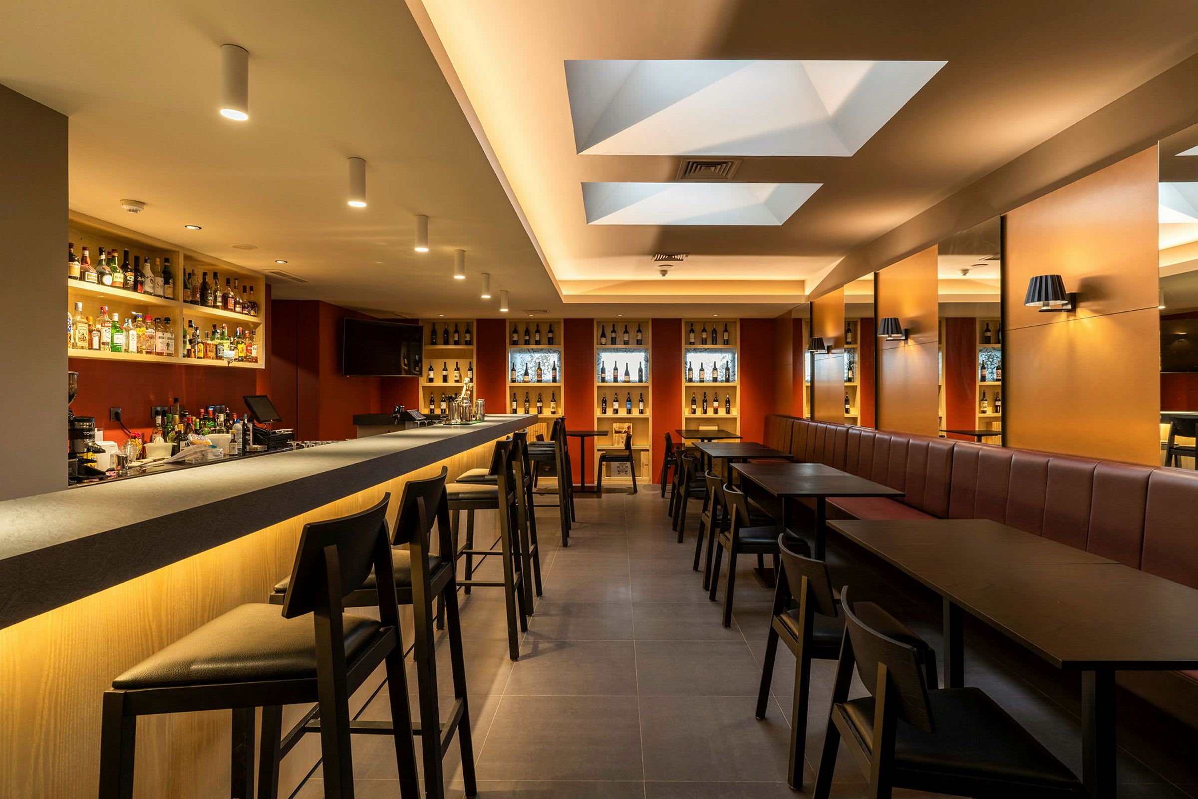 Interiør af en moderne bar med bardisk, stole og borde. (AI-genereret tekst)