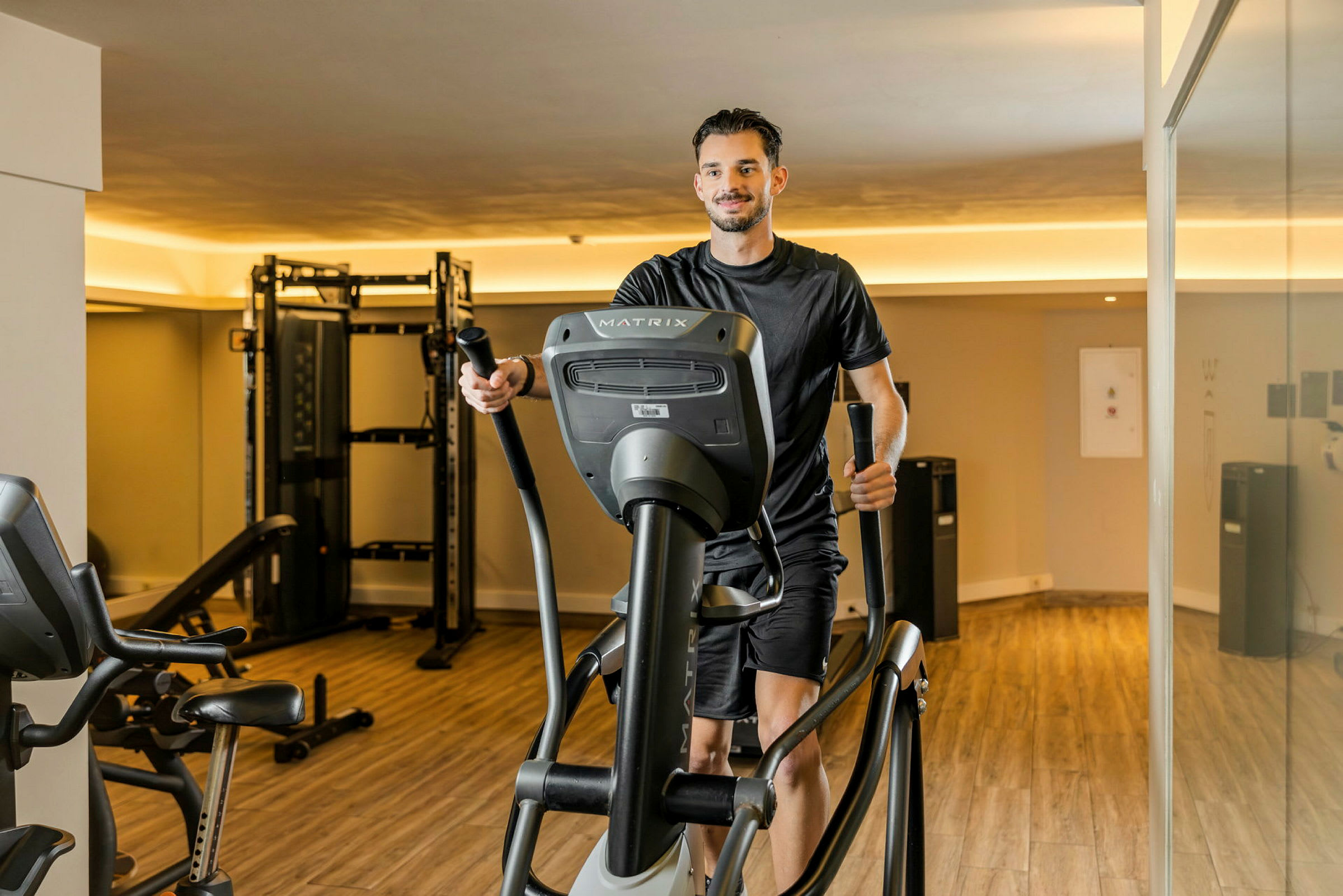 En person træner på en crosstrainer i et fitnesscenter. (AI-genereret tekst)
