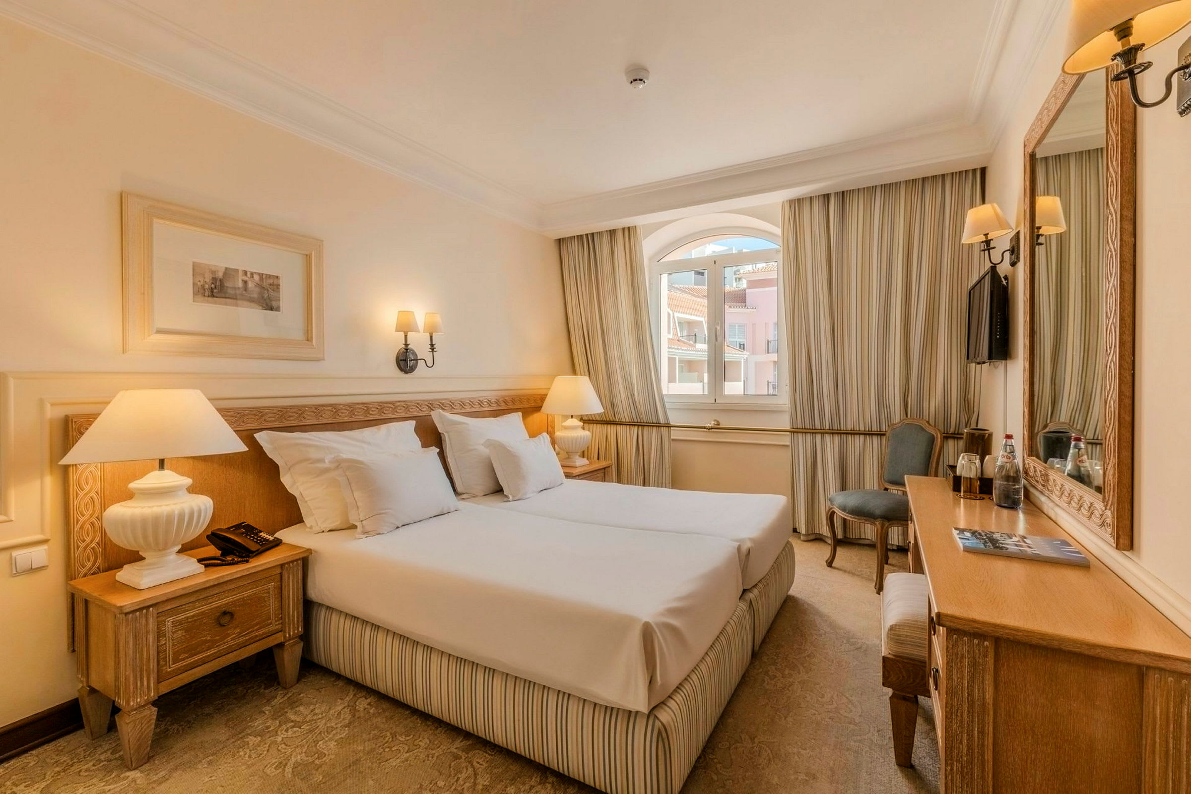 Hotelværelse med dobbeltseng, natbord og elegant indretning. (AI-genereret tekst)
