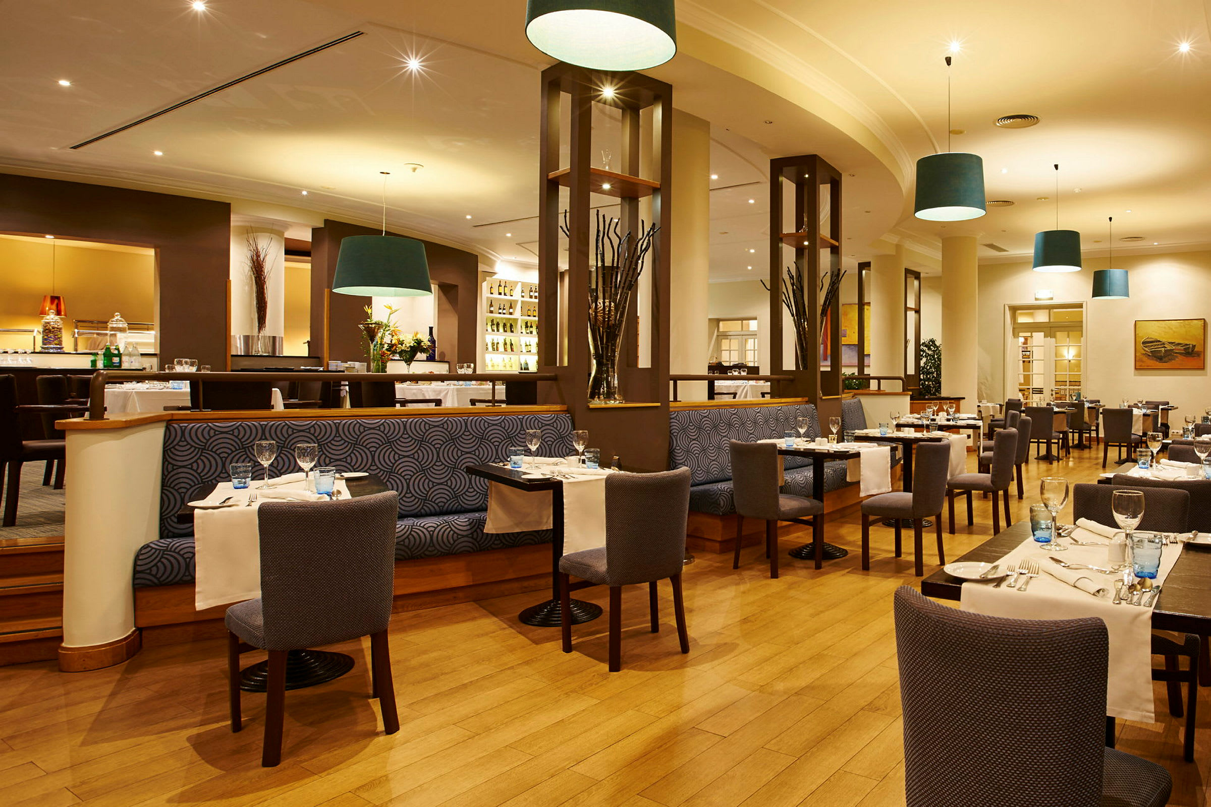 Billede af en elegant restaurant med borde og stole arrangeret til gæster. (AI-genereret tekst)