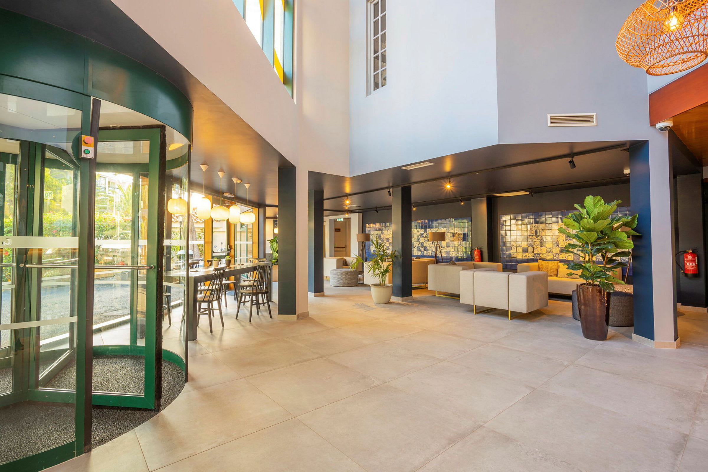 Hotellets lobby med komfortable siddeområder og glasdøre. (AI-genereret tekst)
