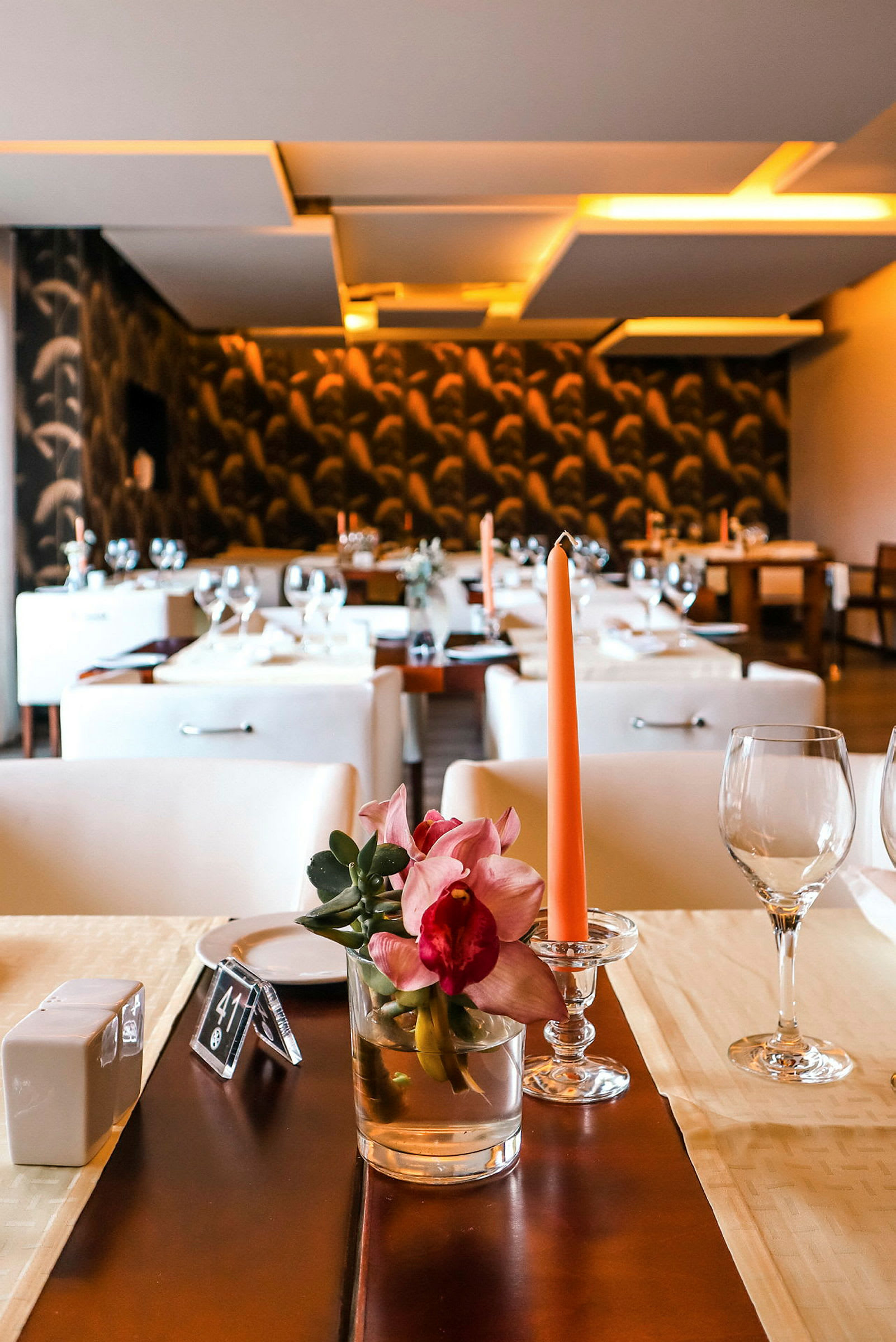 En elegant restaurant med dækkede borde, dekoreret med blomster og lys. (AI-genereret tekst)