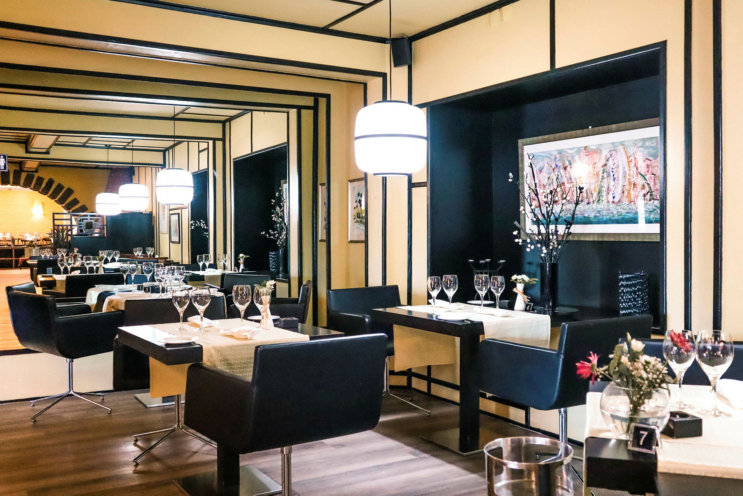 En elegant restaurant med opdækkede borde, stole og moderne belysning. (AI-genereret tekst)