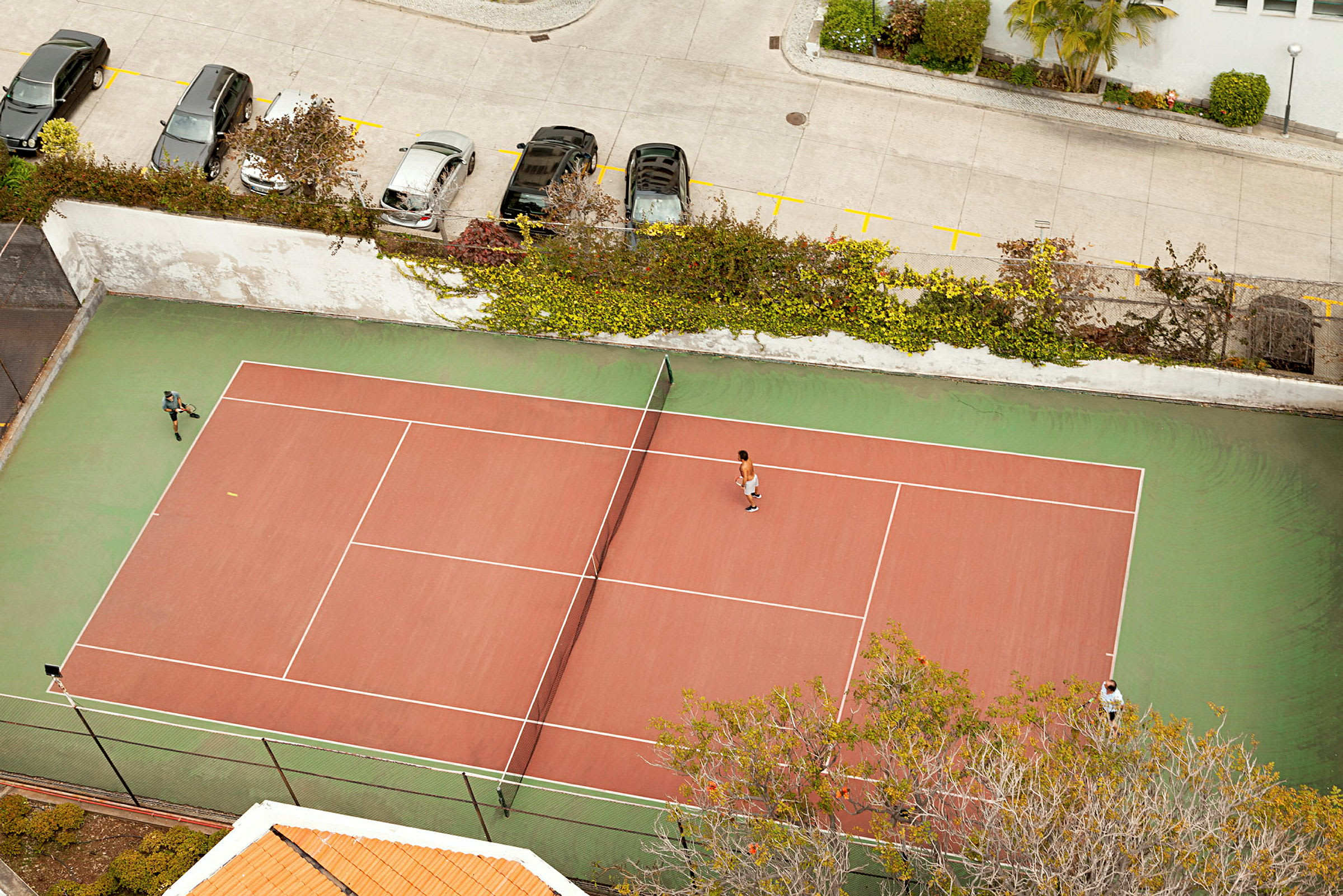 En tennisbane set fra oven, med to spillere i spil. (AI-genereret tekst)