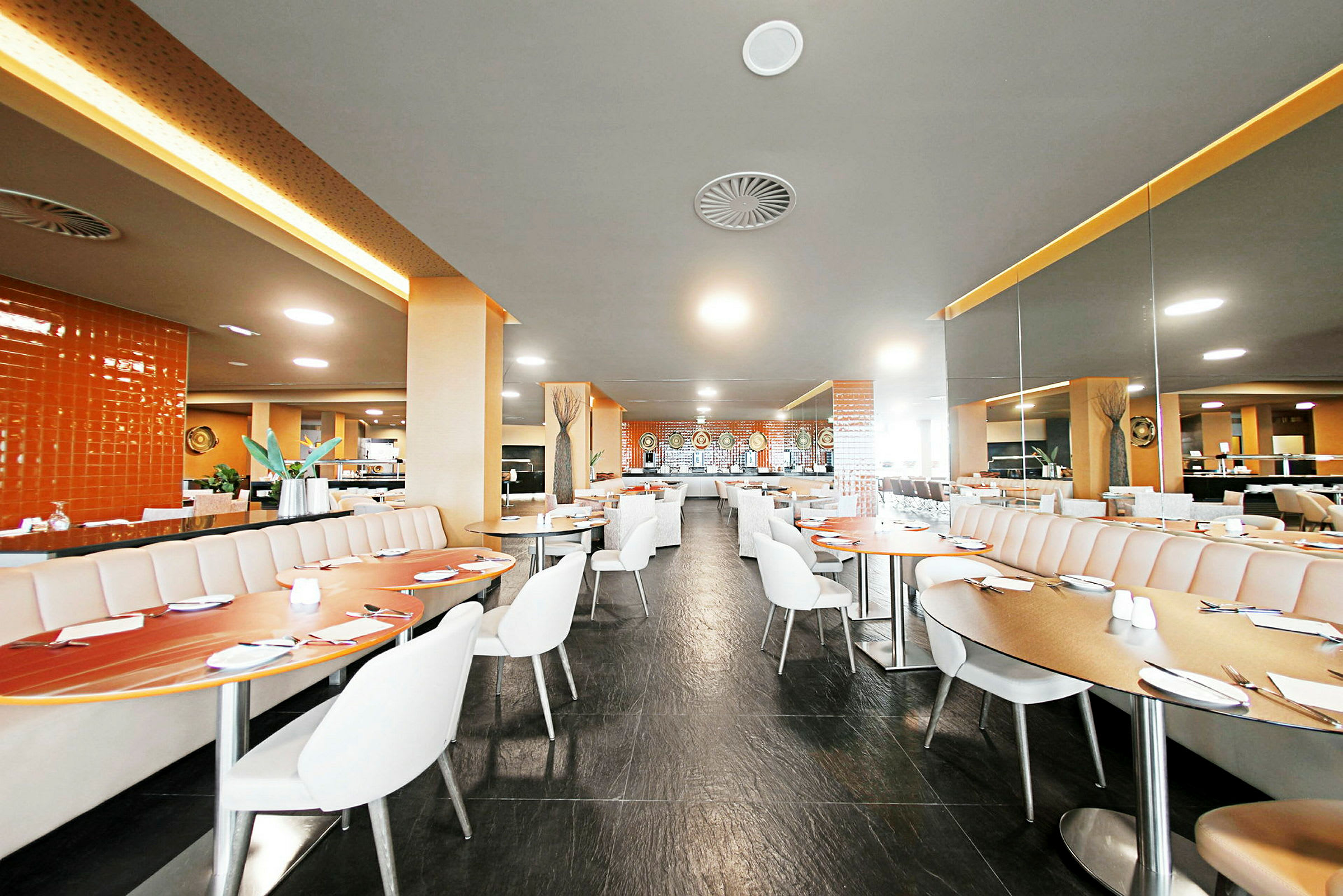 En moderne og lys restaurant med siddepladser og borde. (AI-genereret tekst)
