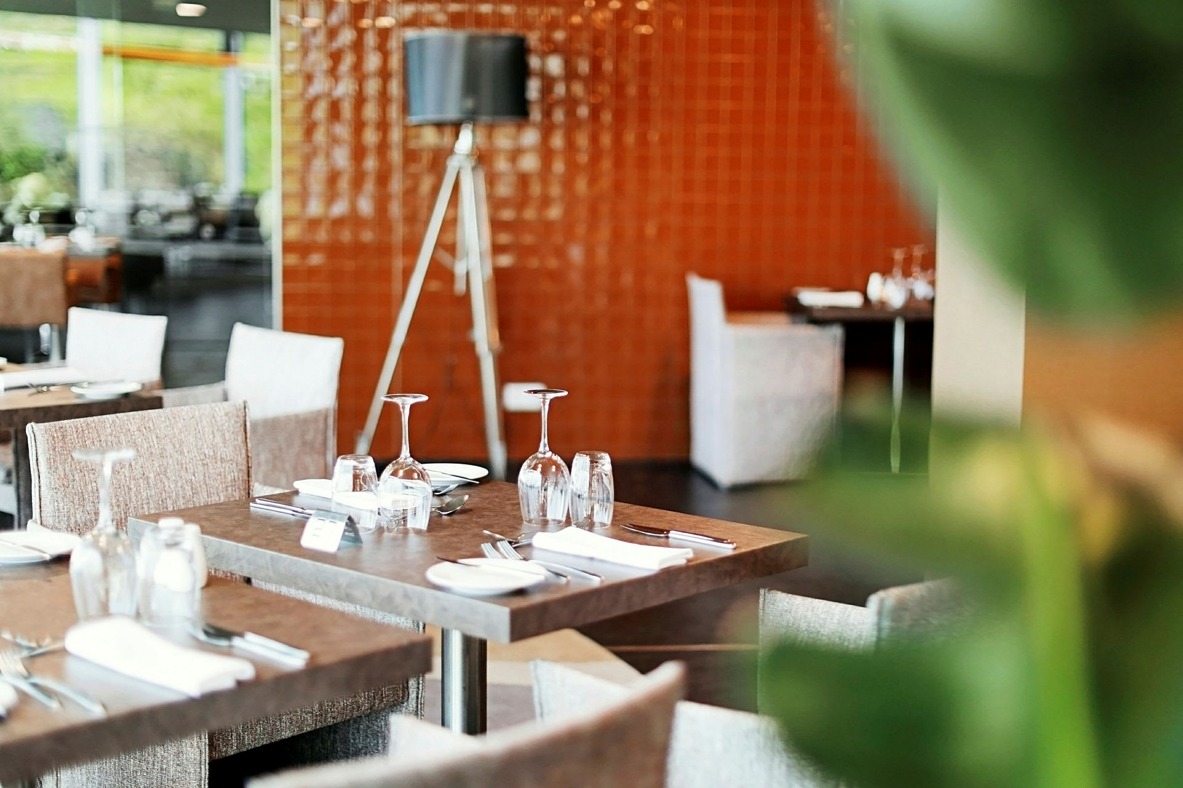 En restaurant med dækkede borde og siddepladser. (AI-genereret tekst)