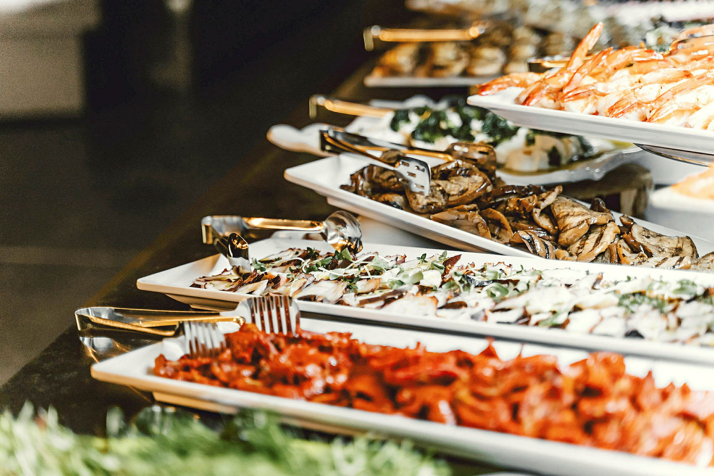 Buffet med forskellige retter, inklusive skaldyr og grøntsager. (AI-genereret tekst)