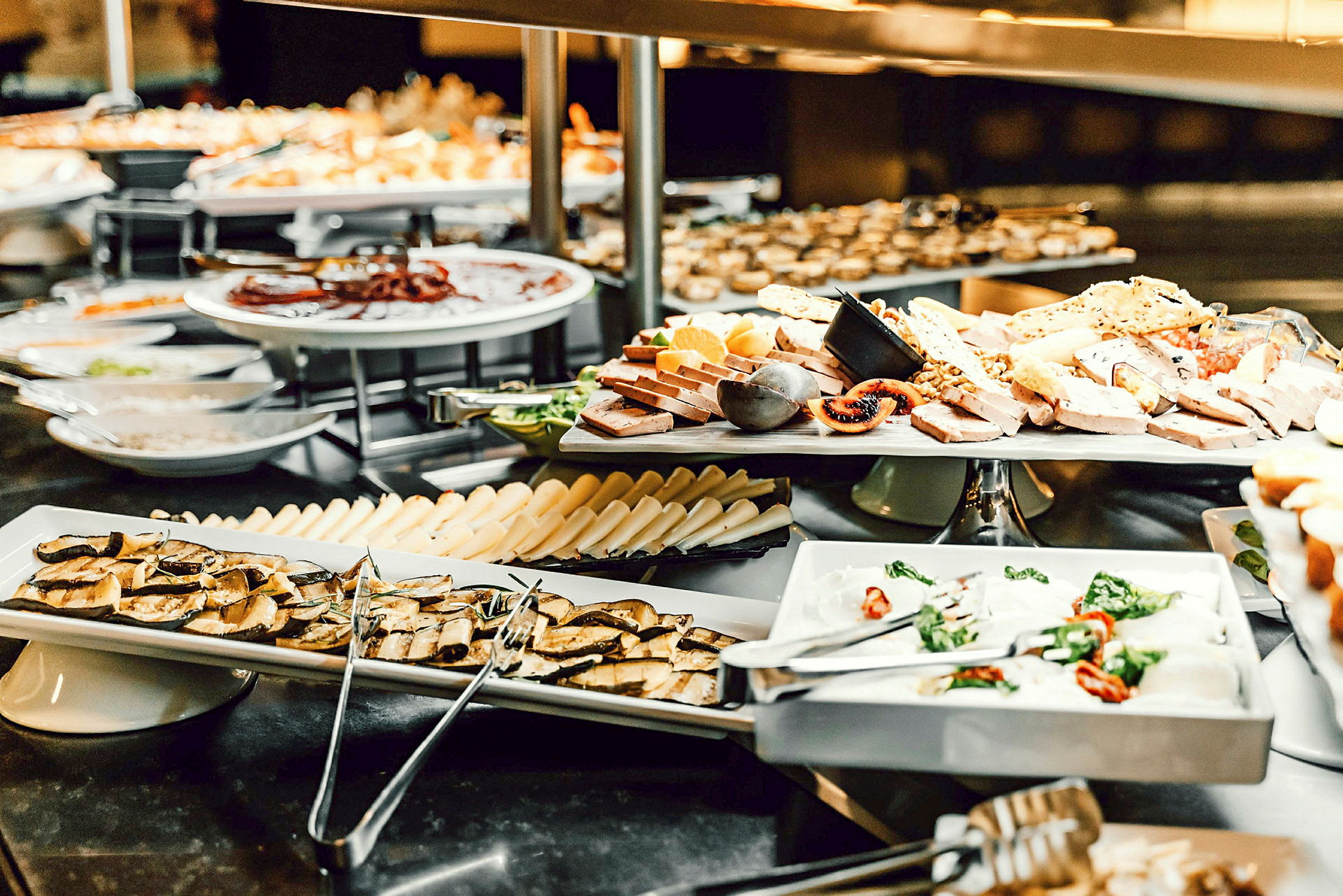 Billede af en buffet med ost, frugt og andre madvarer arrangeret på tallerkener. (AI-genereret tekst)