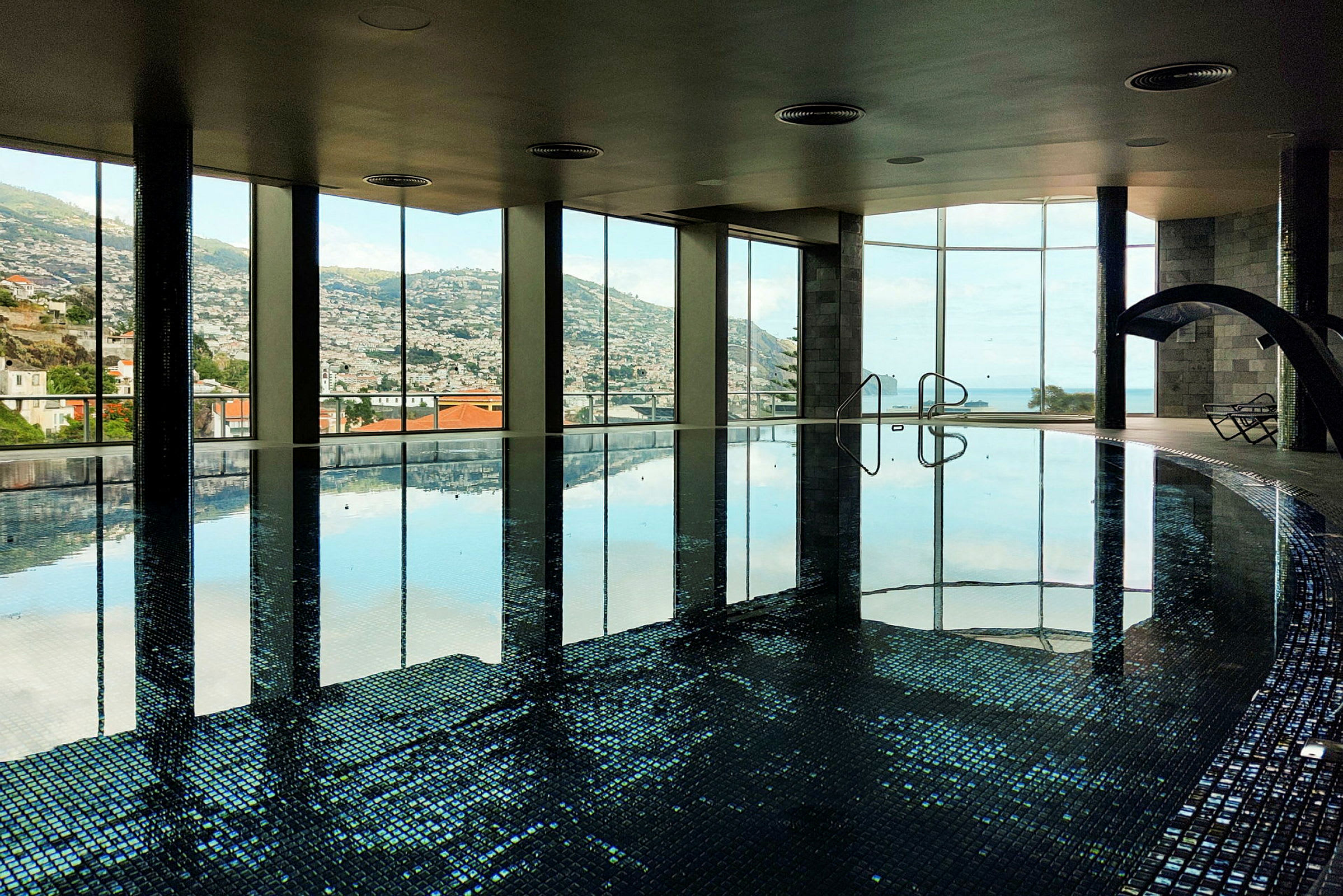 Moderne indendørs swimmingpool med panoramaudsigt. (AI-genereret tekst)