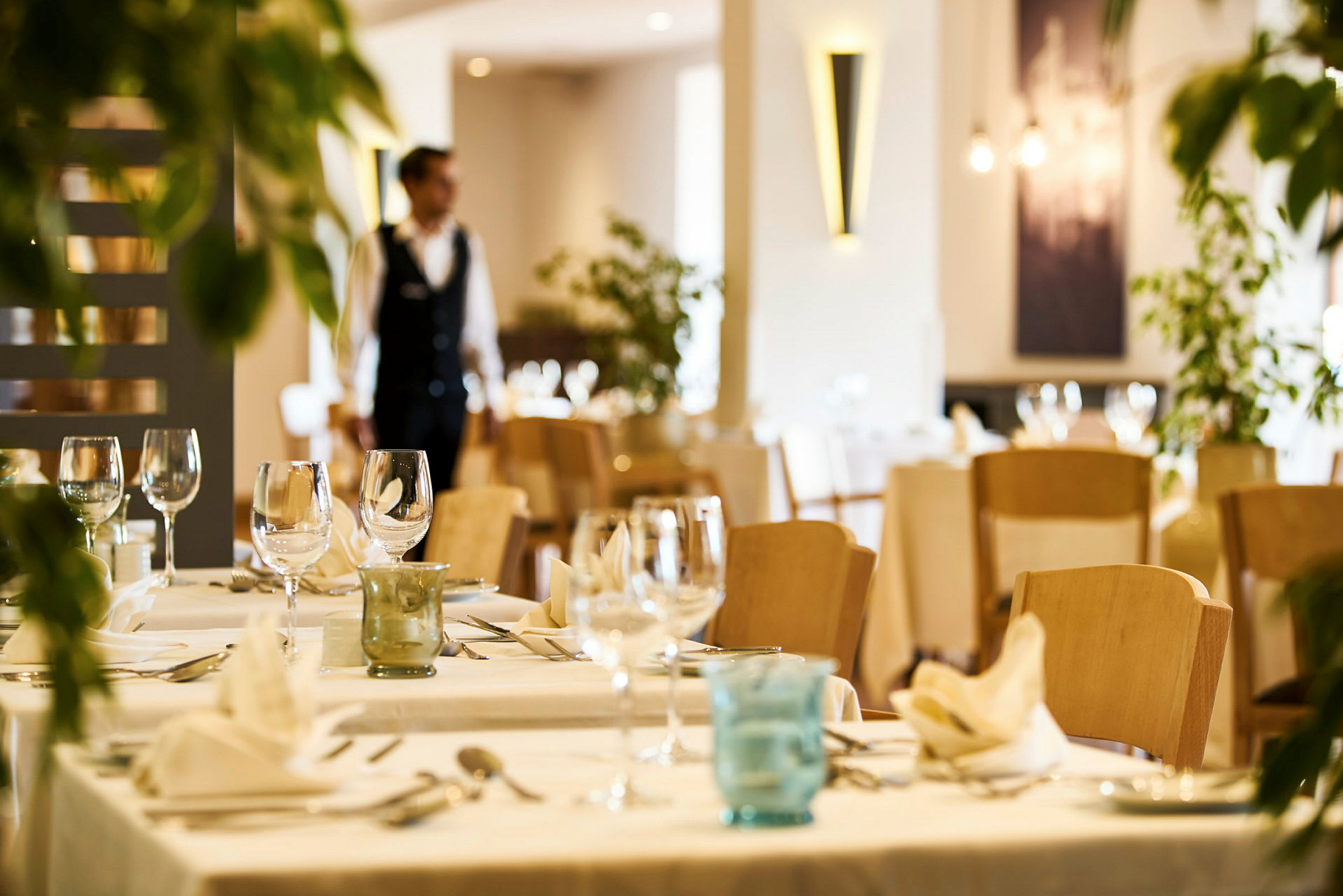 En elegant restaurant med dækkede borde og stole. (AI-genereret tekst)