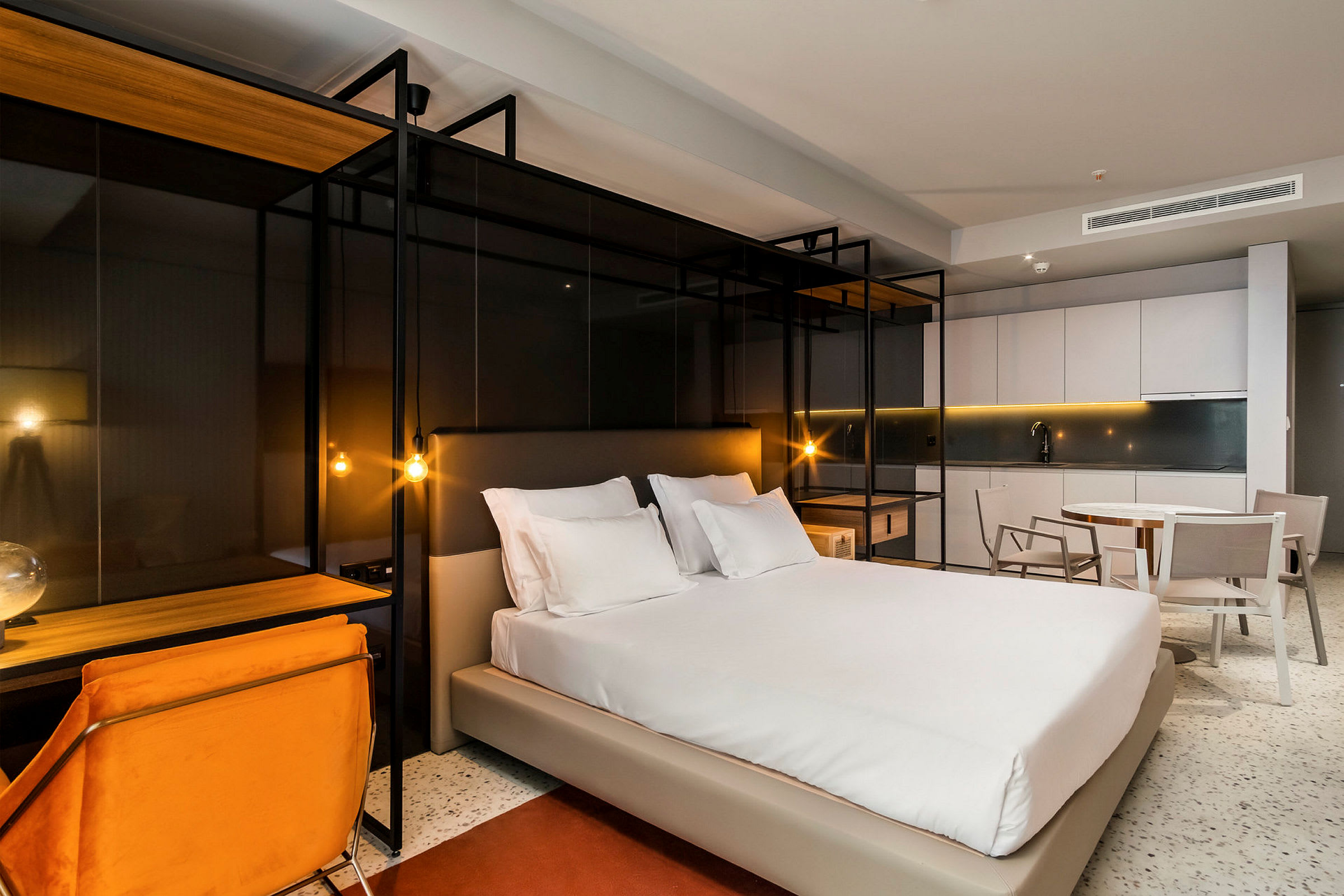 Moderne indrettet hotelværelse med en dobbeltseng, skrivebord og siddeplads. (AI-genereret tekst)
