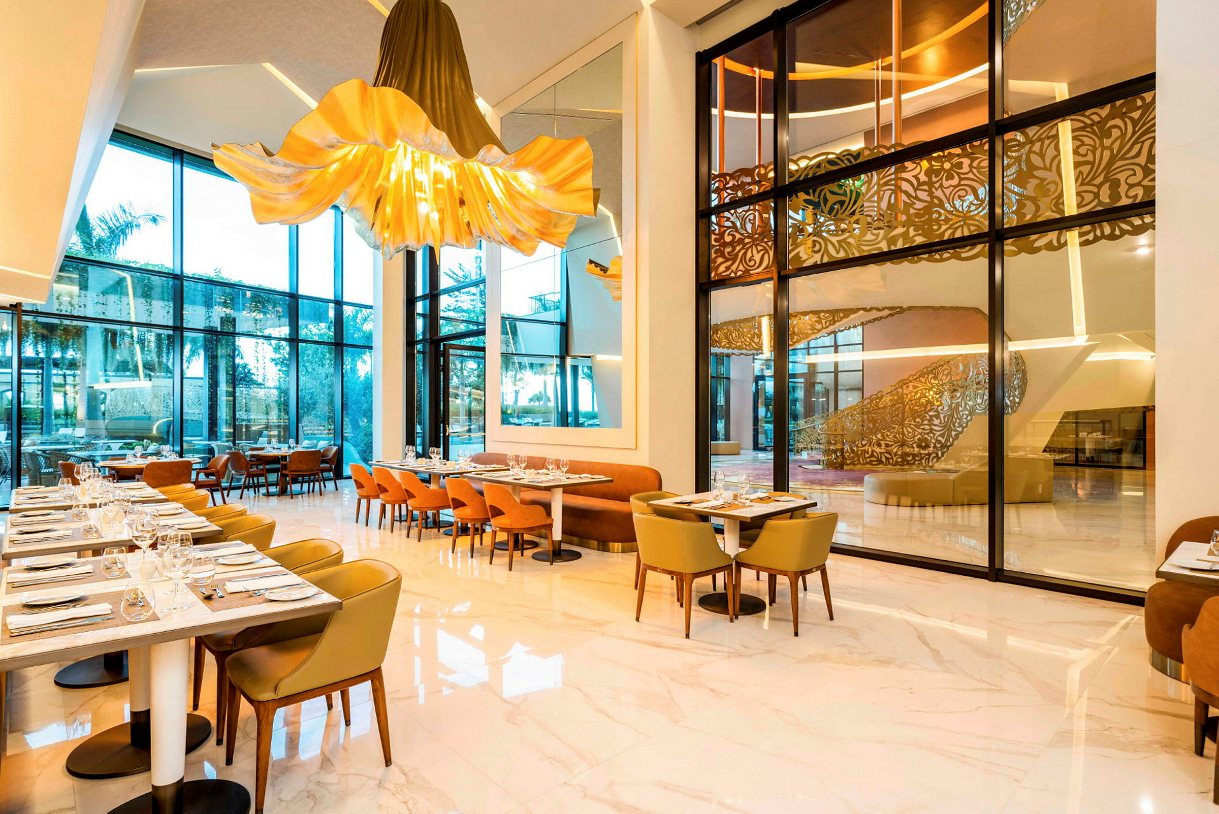 Moderne restaurant med store glasvinduer, elegante stole og belysning. (AI-genereret tekst)