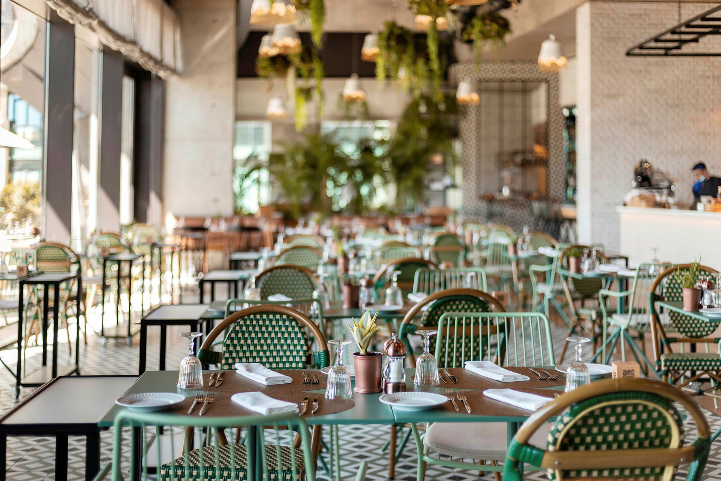 Interiør af en restaurant med dækkede borde og stole. (AI-genereret tekst)