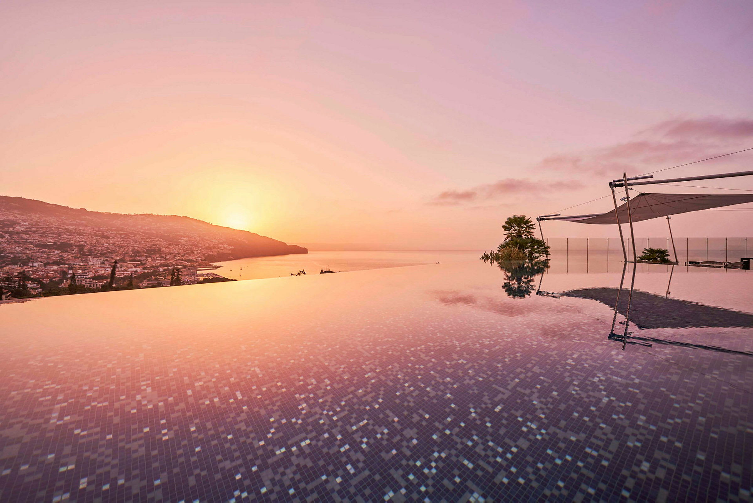 Infinity-pool med udsigt over byen og havet ved solnedgang. (AI-genereret tekst)