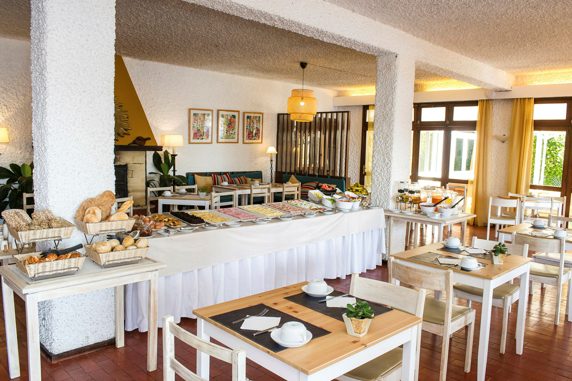 Et hotelrestaurantområde med en morgenmadsbuffet og siddepladser. (AI-genereret tekst)