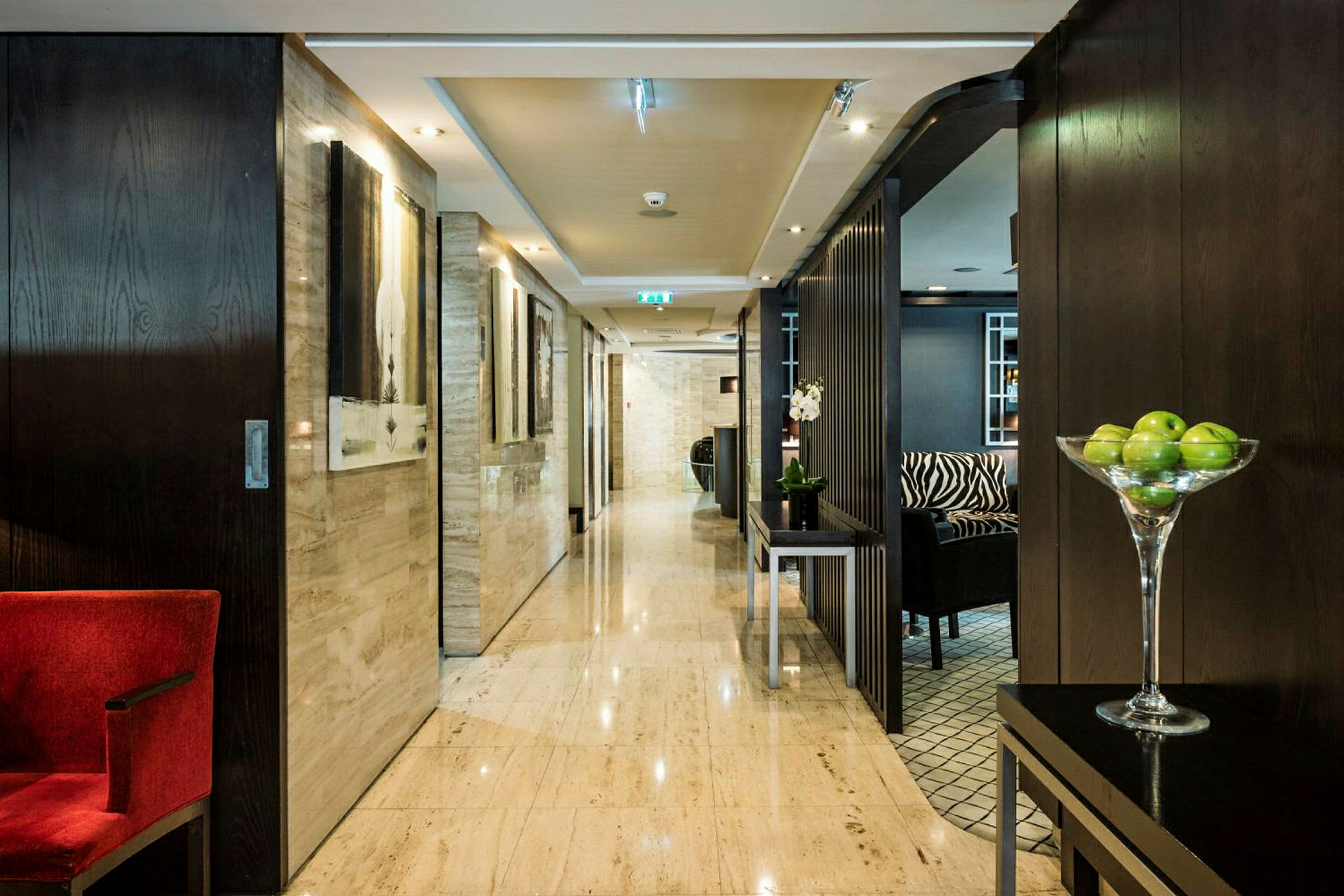 Hotelkorridor med moderne indretning og grønne æbler i en skål. (AI-genereret tekst)