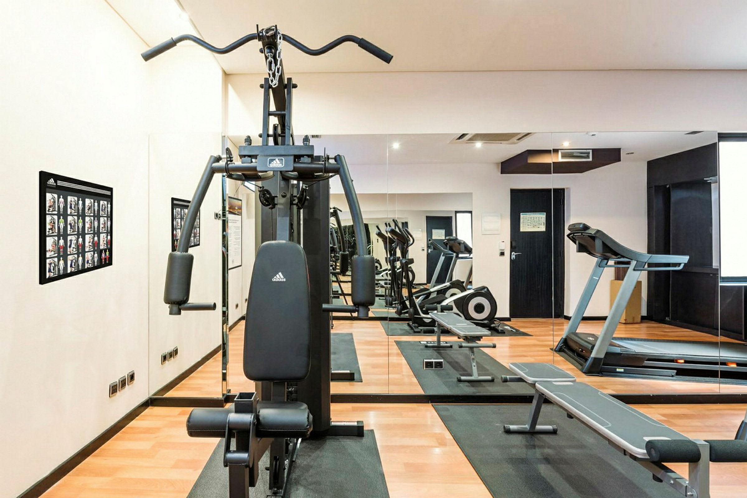 Fitnessrum med træningsmaskiner og spejle. (AI-genereret tekst)