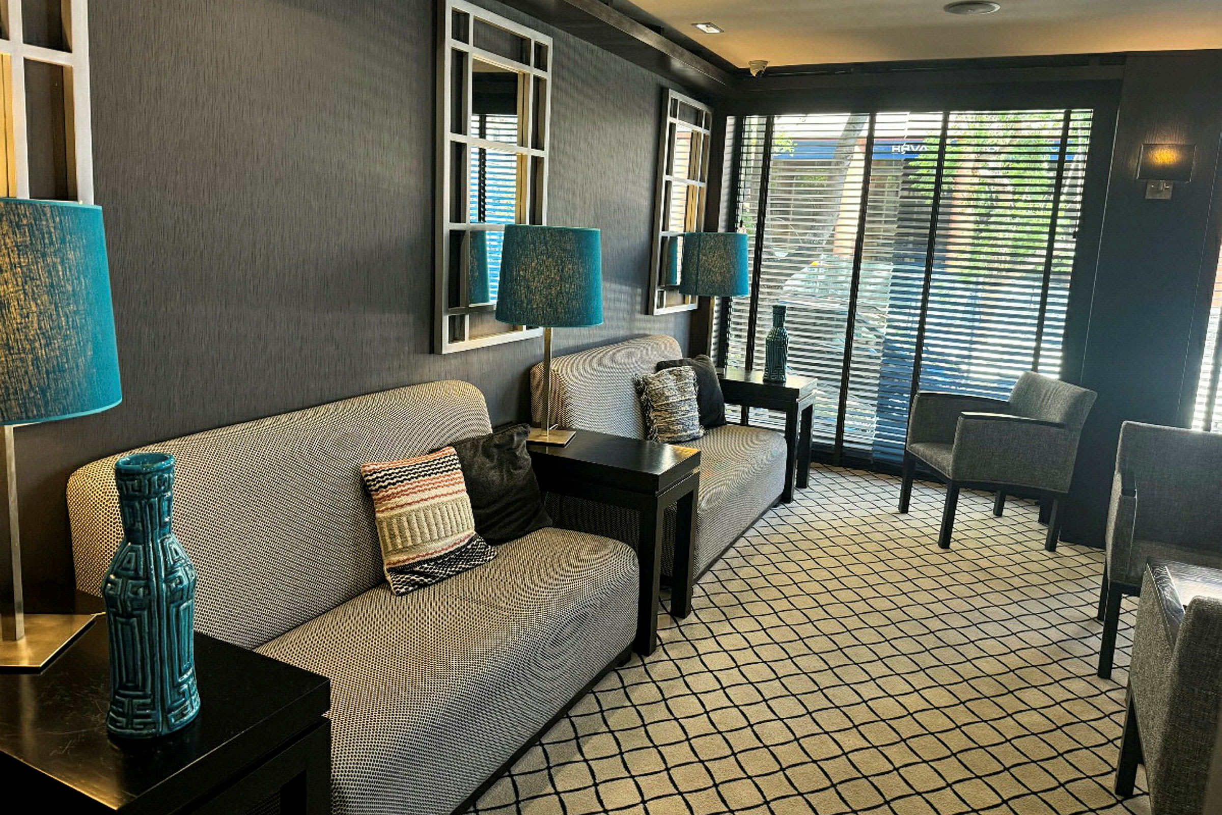 En hotellobby med sofaer, blå lamper og moderne detaljer. (AI-genereret tekst)