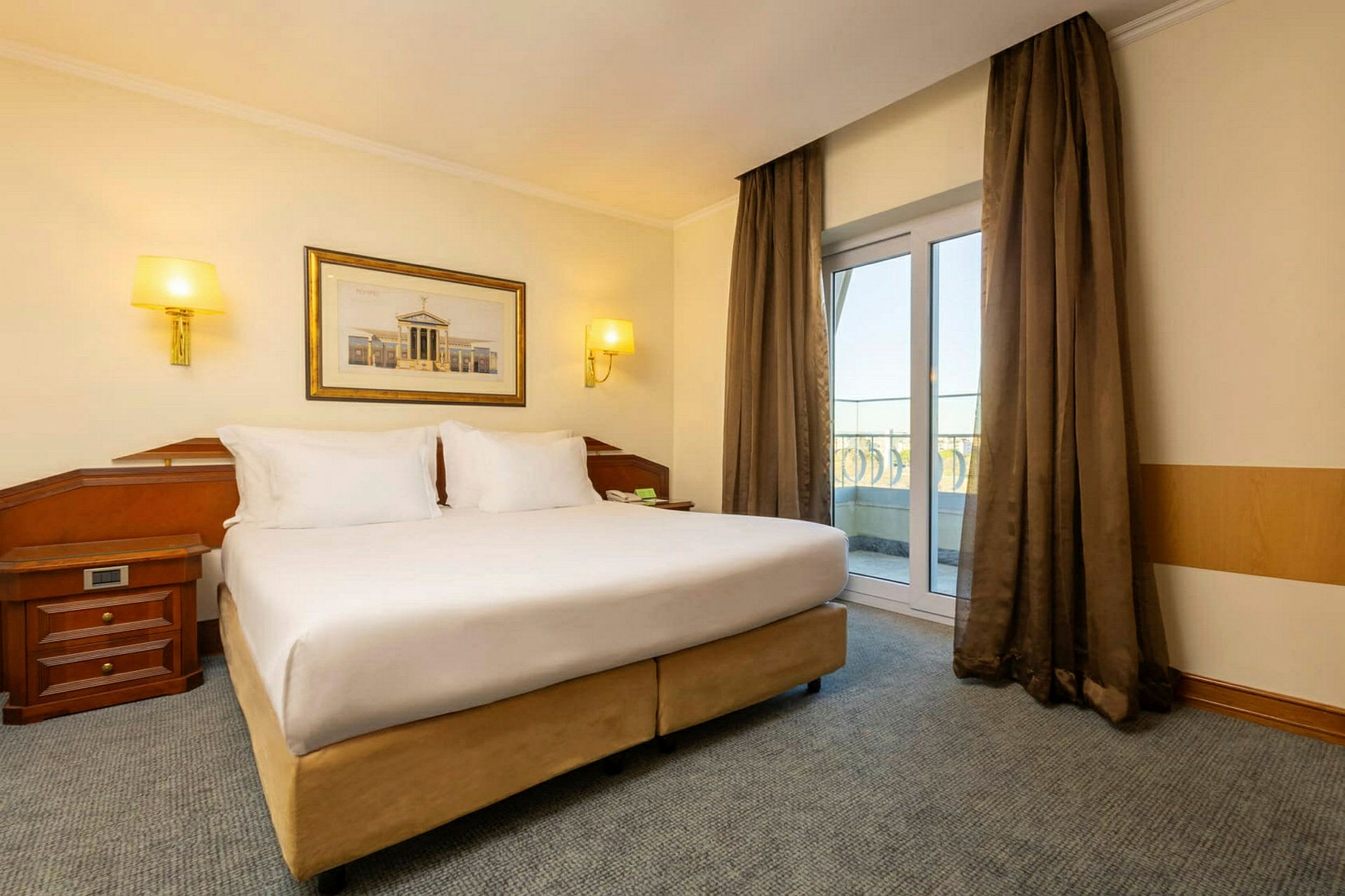 Et hotelværelse med en stor dobbeltseng og vinduer ud til balkonen. (AI-genereret tekst)