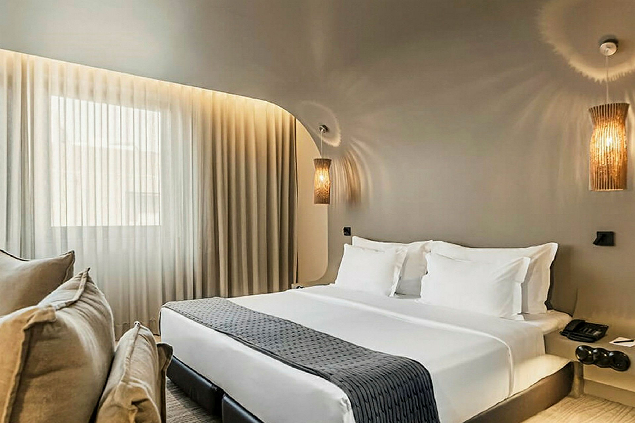 Hotelværelse med dobbeltseng, hvide sengelagner og dekorative sengelamper. (AI-genereret tekst)