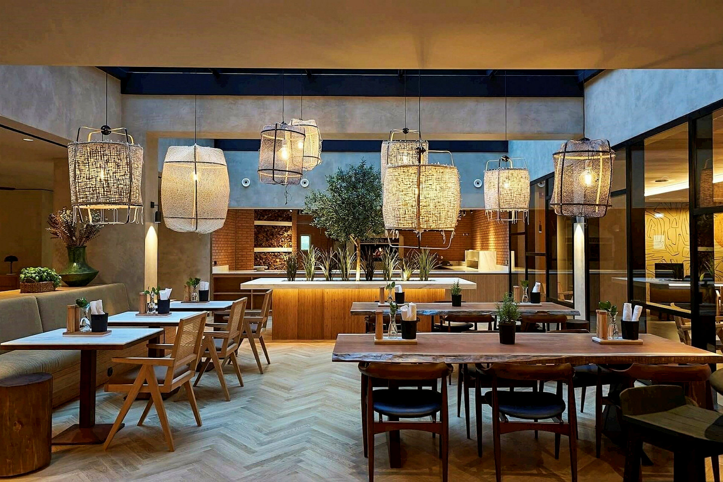 Interiør af en restaurant med træborde, stole og store hængende lamper. (AI-genereret tekst)