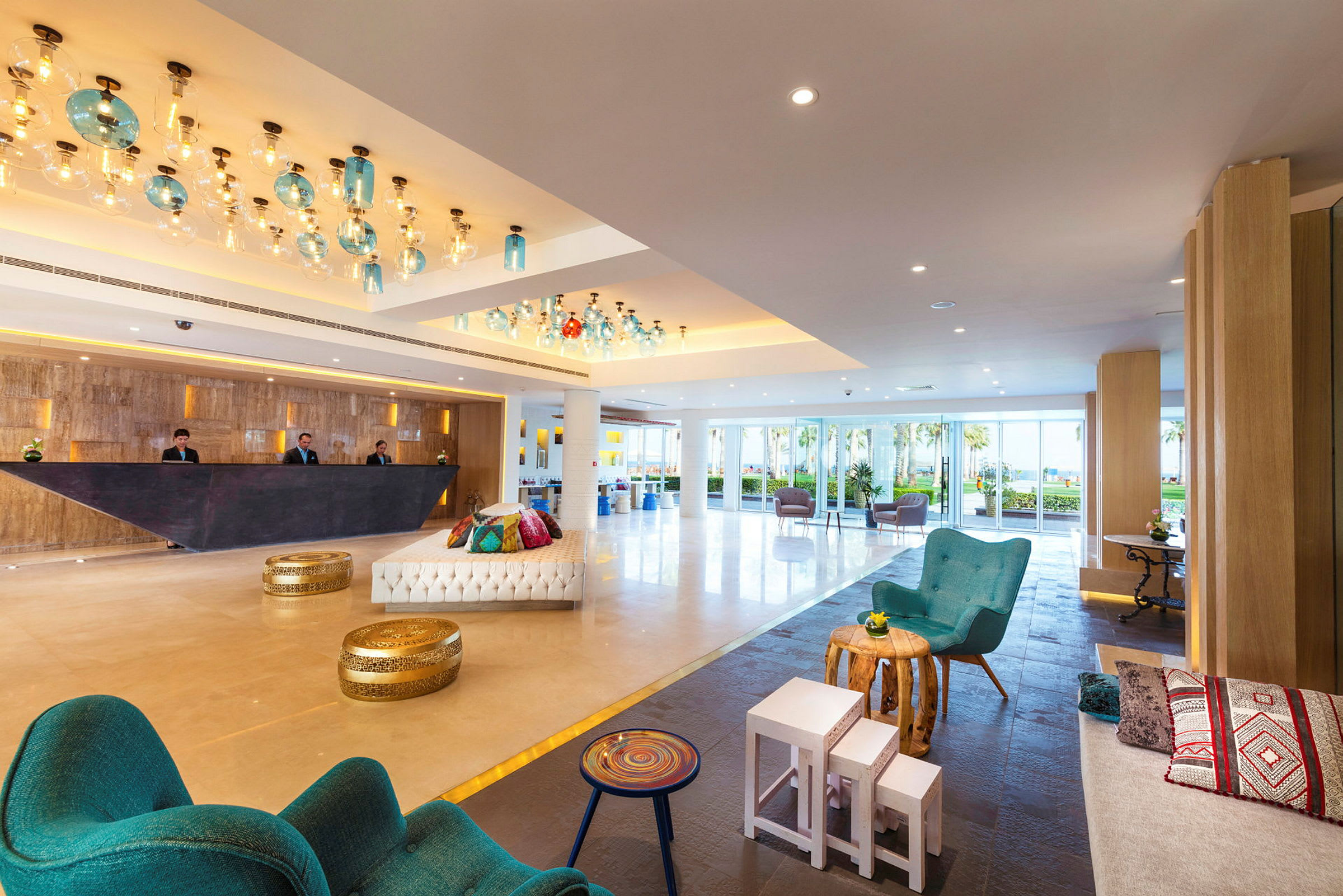 En hotellobby med siddepladser, en moderne reception og lysdekoration. (AI-genereret tekst)