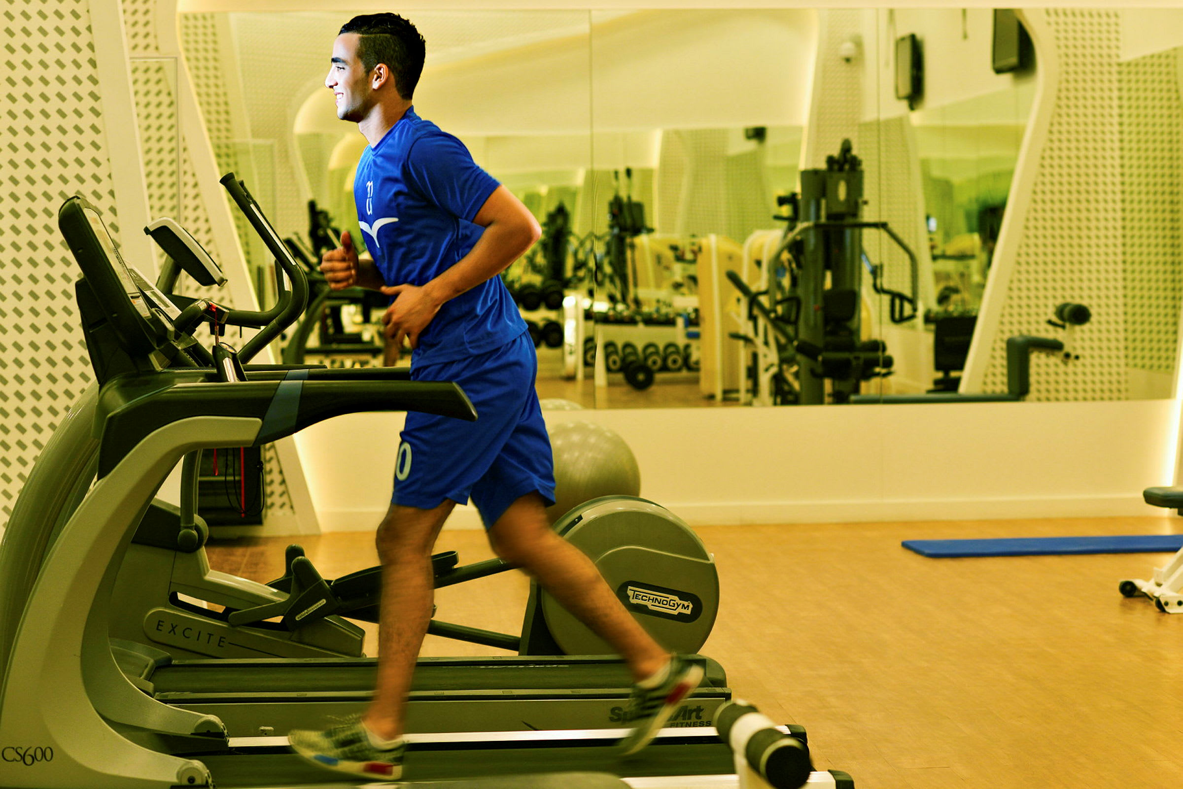 Person træner på et løbebånd i et fitnesscenter. (AI-genereret tekst)