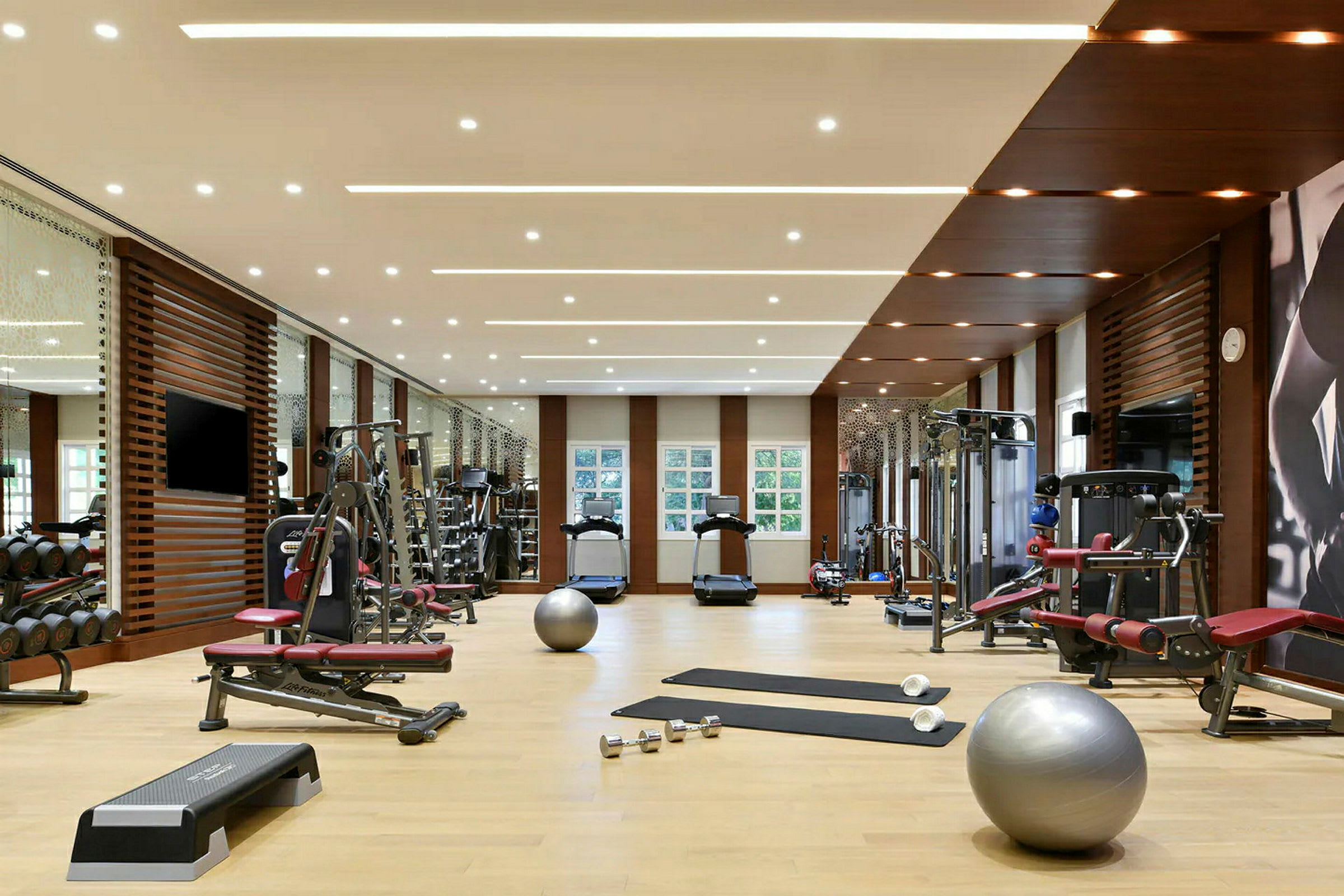 Et fitnesscenter med forskellige træningsmaskiner, håndvægte, yogamåtter og træningsbolde. (AI-genereret tekst)