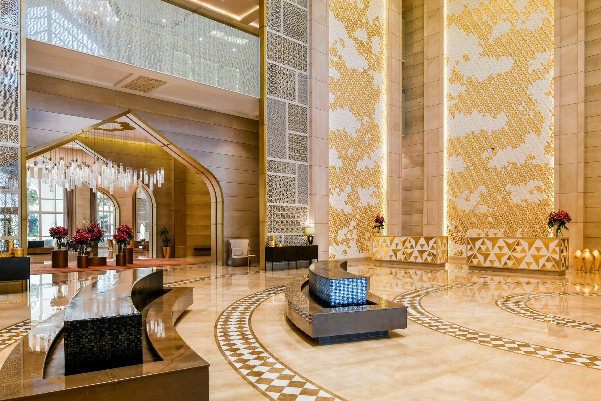 En elegant indrettet hotellobby med højt til loftet, dekorativt mønstret gulv og moderne møbler. (AI-genereret tekst)