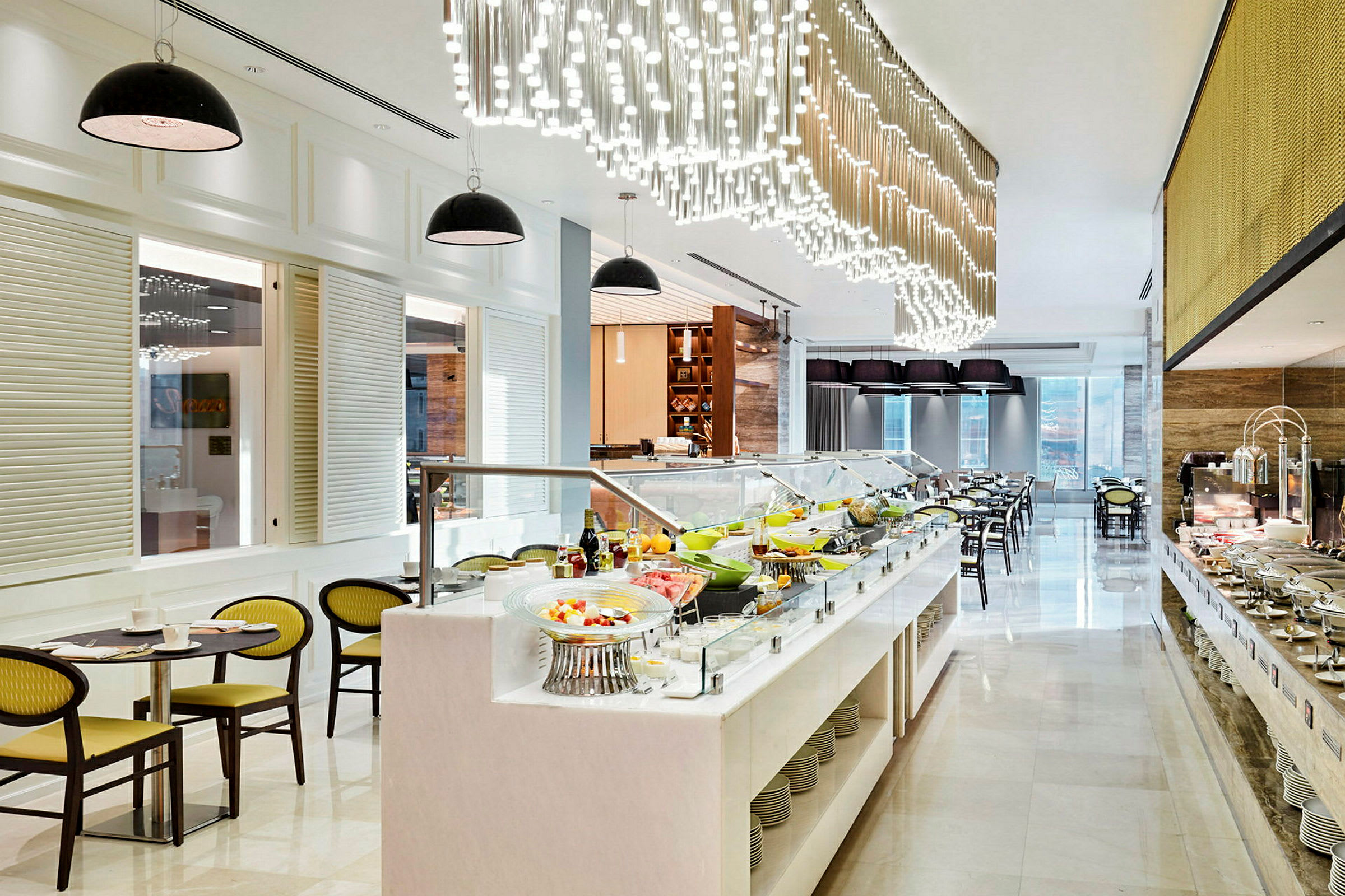 En restaurant med en buffet fyldt med mad og salater. Moderne indretning med hængende lamper og siddepladser i baggrunden. (AI-genereret tekst)