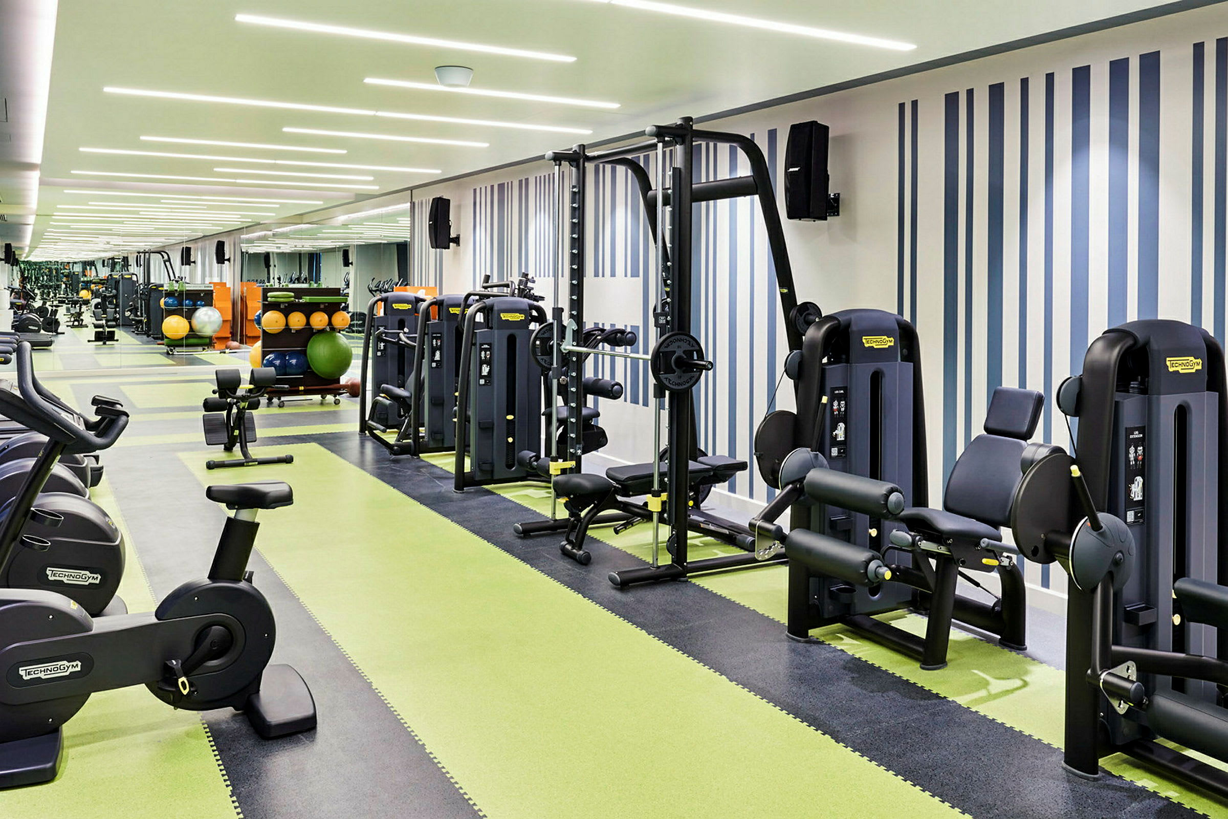 Et moderne fitnesscenter med forskellige træningsmaskiner og frie vægte. (AI-genereret tekst)