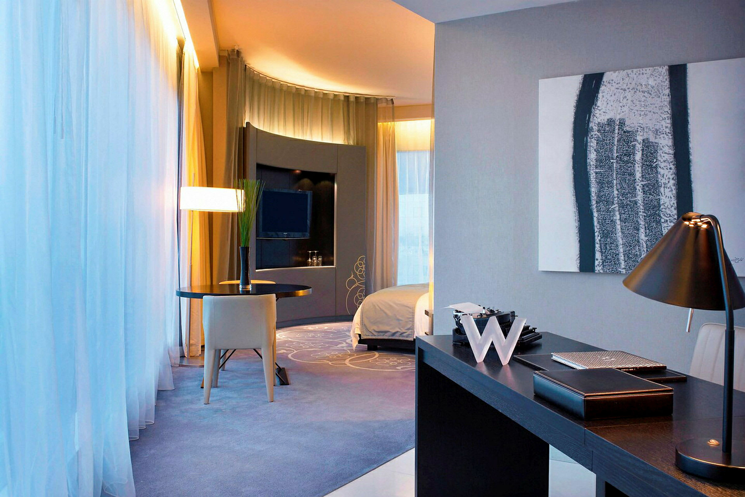 Moderne indrettet hotelværelse med skrivebordslampe, bord og TV. (AI-genereret tekst)