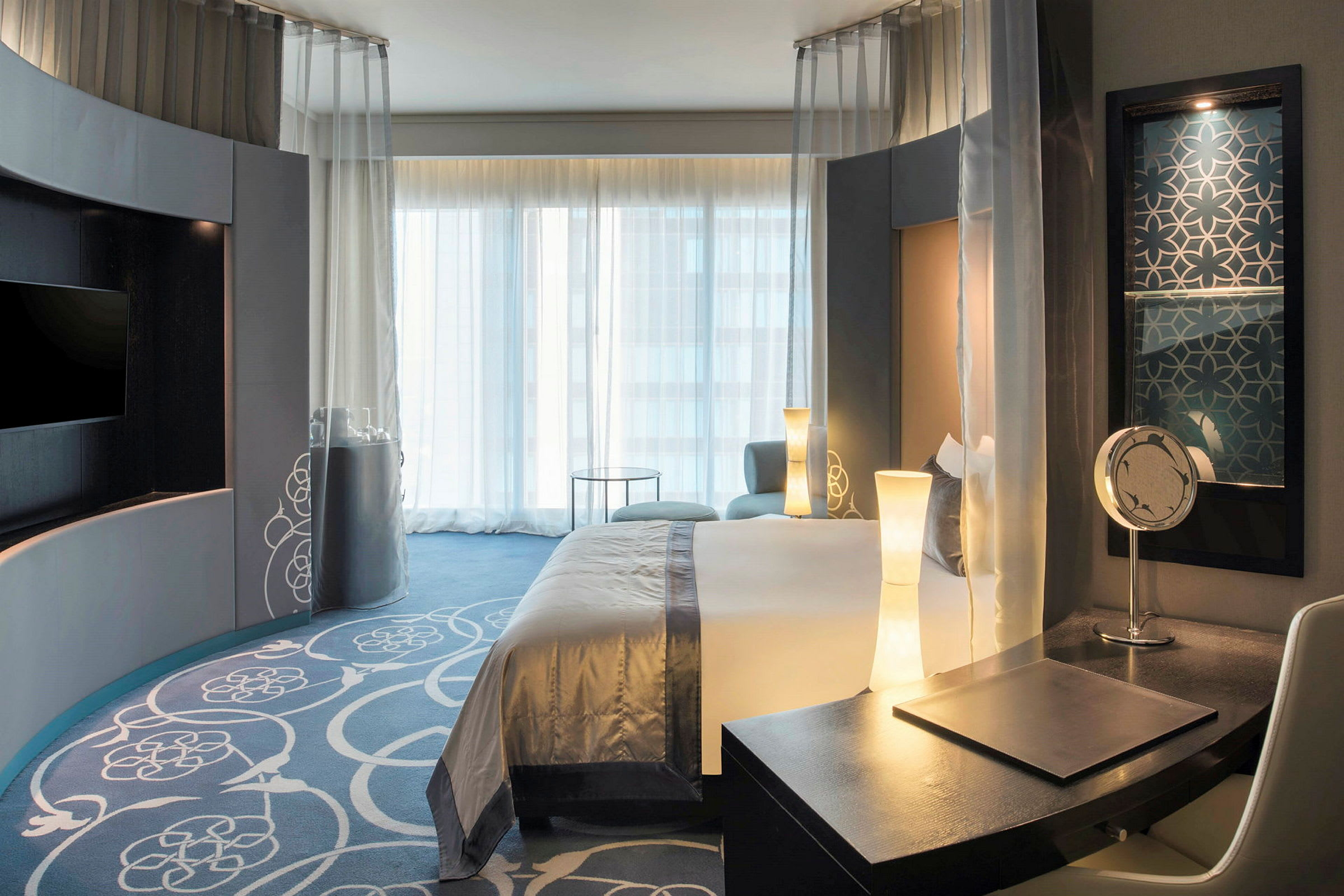 Hotelværelse med moderne indretning, seng og skrivebord. (AI-genereret tekst)