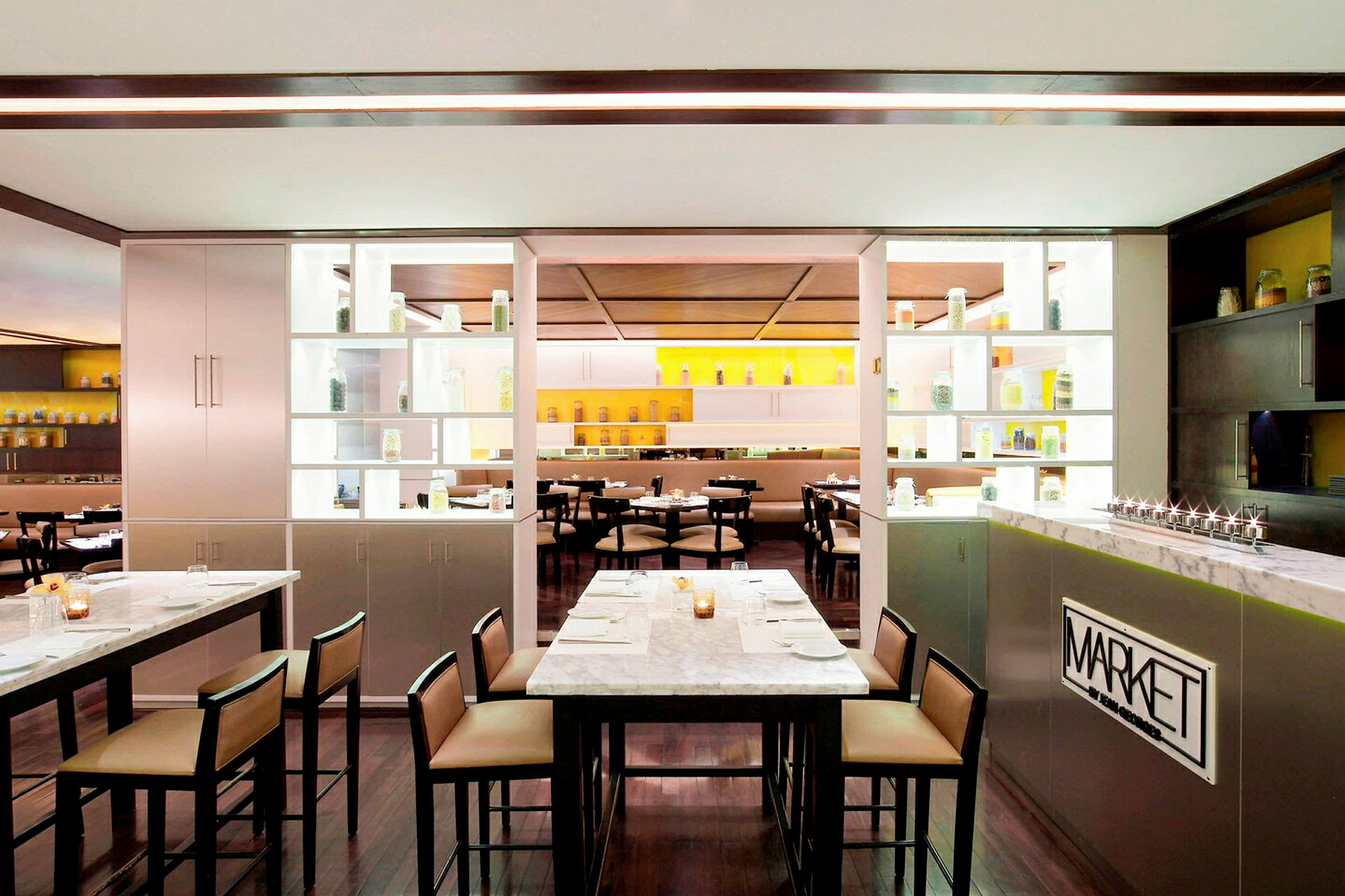 Et moderne restaurantinteriør med marmorborde og hylder med glasbeholdere. (AI-genereret tekst)