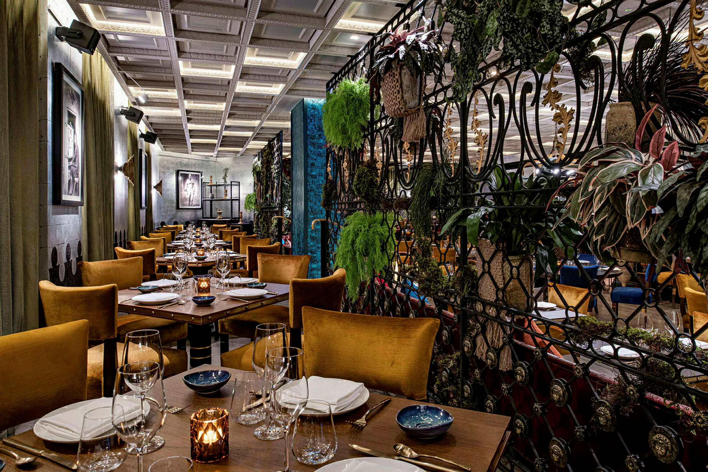 Interiør af en elegant restaurant med opdagte borde og stole samt frodige planter som dekoration. (AI-genereret tekst)
