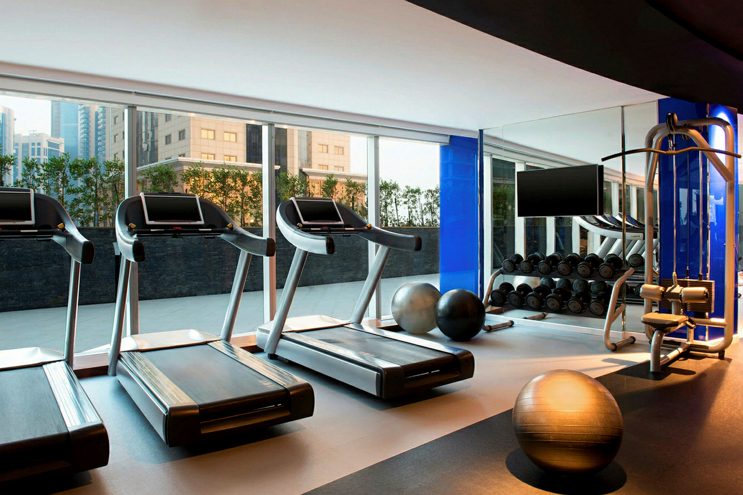 Et fitnesscenter med løbebånd, træningsbolde og vægtstativer. (AI-genereret tekst)