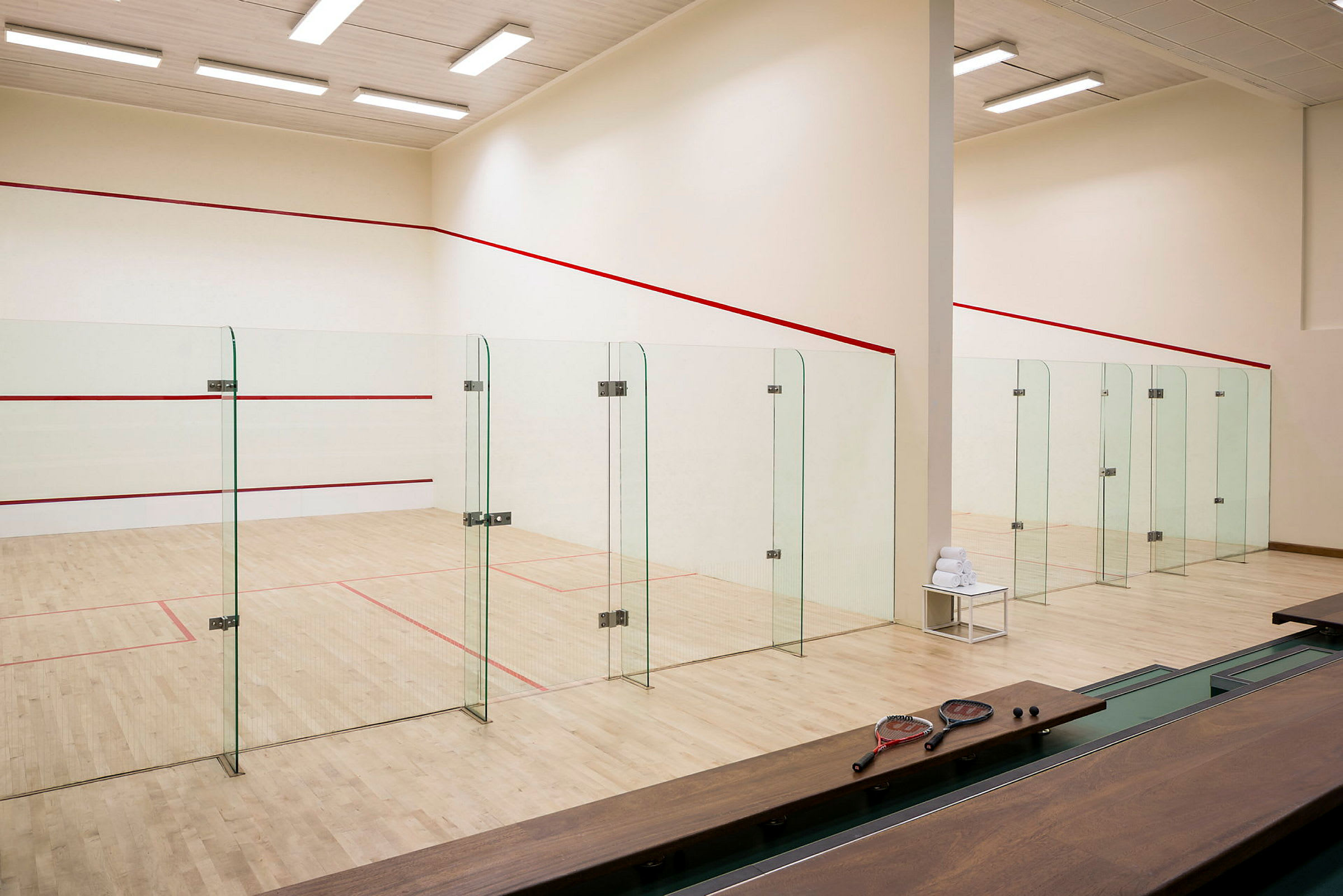 Squashbaner med glasvægge fotograferet indendørs. (AI-genereret tekst)