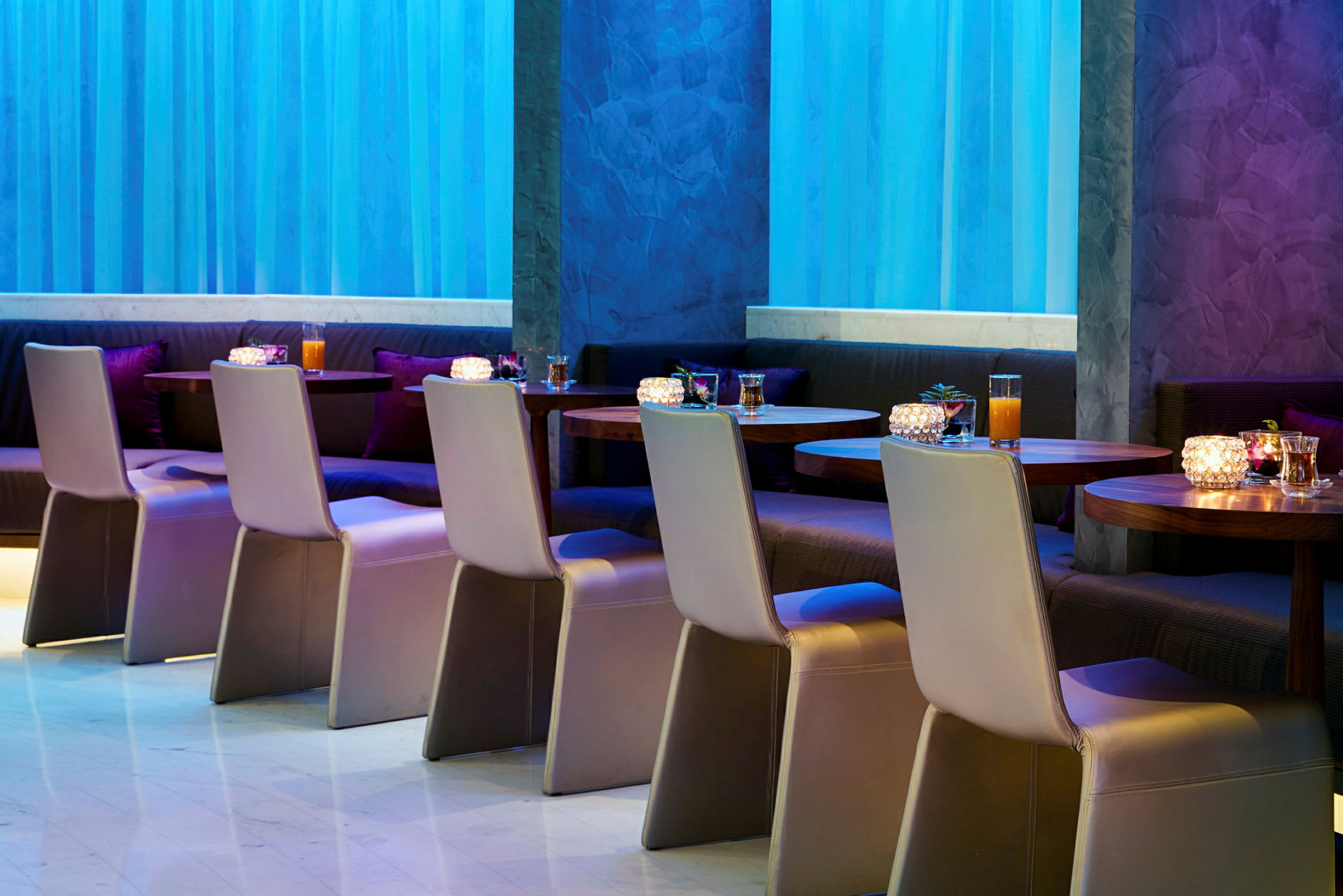 Restaurant med borde og stole opstillet i et moderne indendørsmiljø. (AI-genereret tekst)