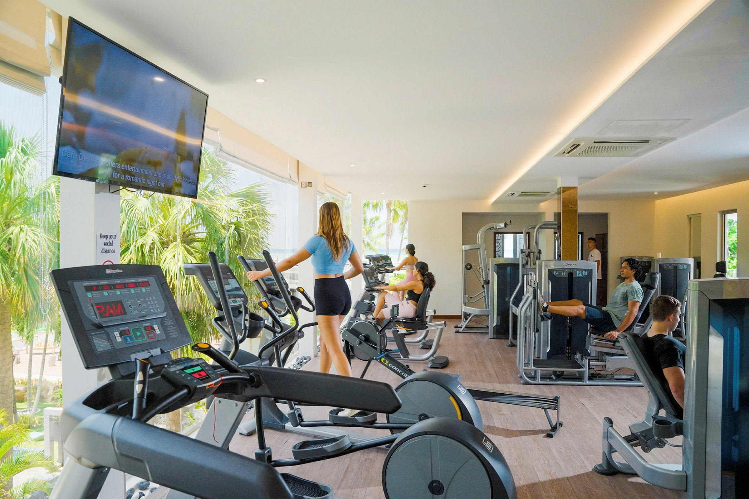 Et moderne fitnesscenter med træningsudstyr og personer, der træner. (AI-genereret tekst)