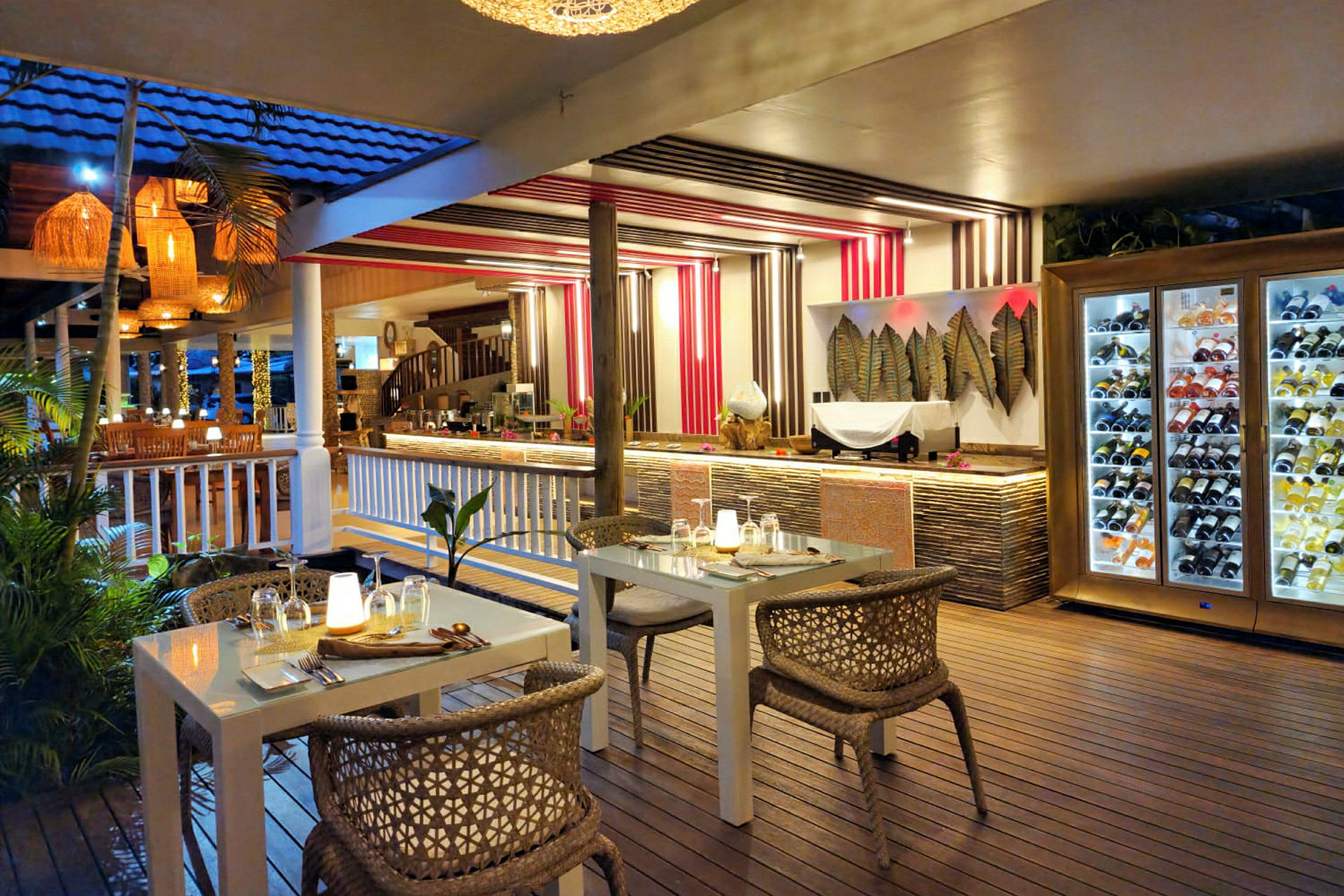 En restaurant med moderne møbler og indretning, herunder et bord med dæmpet belysning og en vinopbevaringsenhed. (AI-genereret tekst)